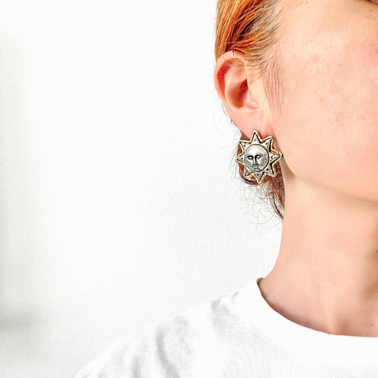 A charming pair of JJ sun earrings featuring a gentle smiling face. 穏やかな微笑みをたたえた、JJの太陽ピアス。