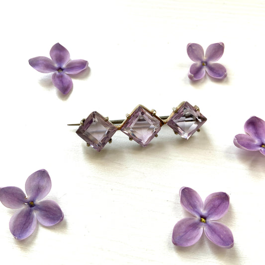 A silver bar brooch featuring a row of beautiful, translucent lavender-coloured diamond-shaped amethysts.  透明感のある美しいラベンダーカラーのダイヤ型アメジストが並んだシルバーのバーブローチ。