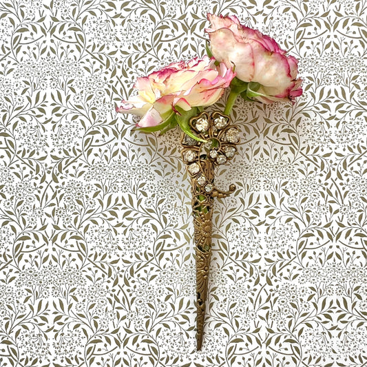 A decorative posy holder crafted from gold-tone filigree and adorned with sparkling rhinestones. ゴールドトーンのフィリグリーにラインストーンがあしらわれた、装飾的なポージーホルダー。
