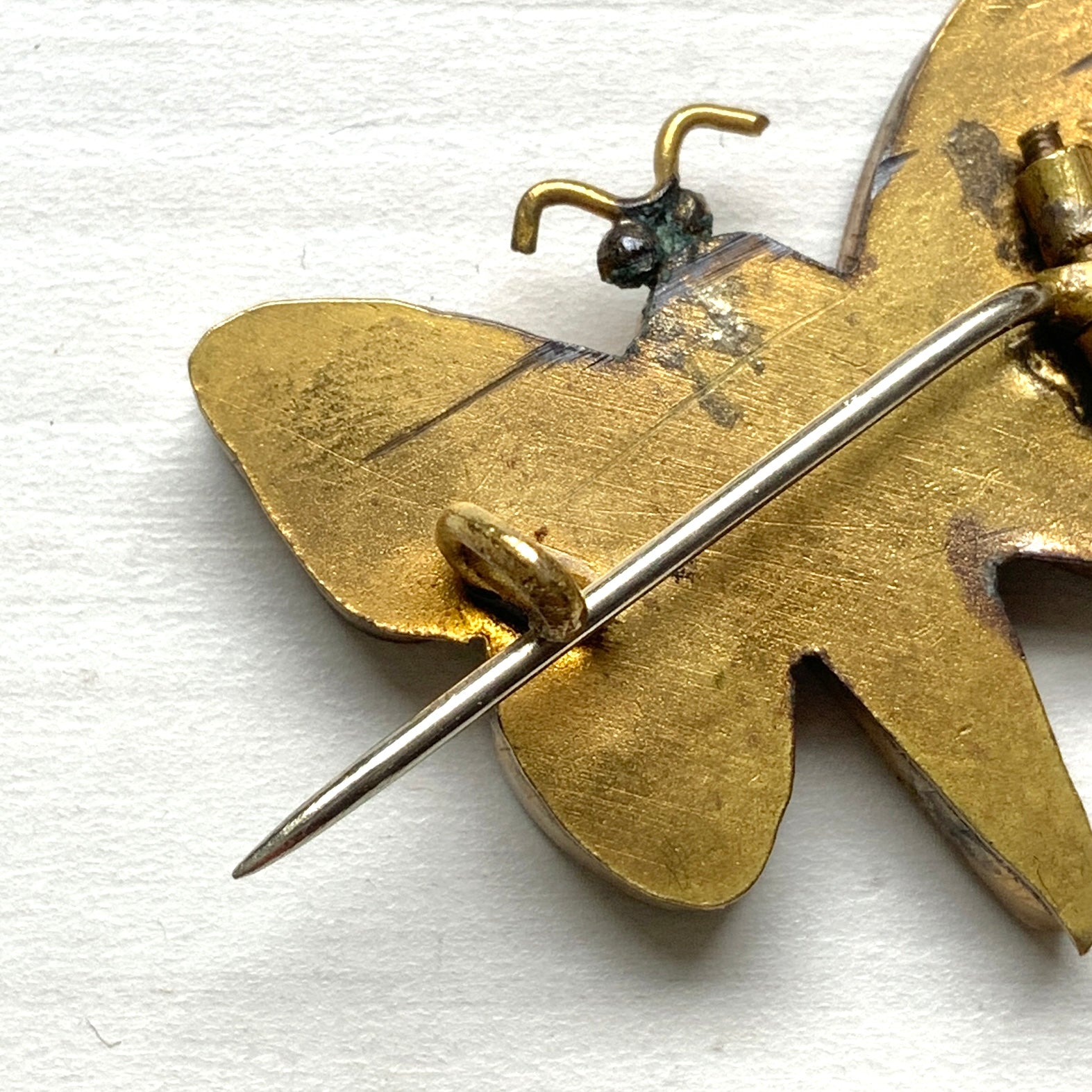 A micro mosaic butterfly brooch featuring delicate floral designs on its wings. お花が羽に入ったマイクロモザイク の蝶々のブローチ。