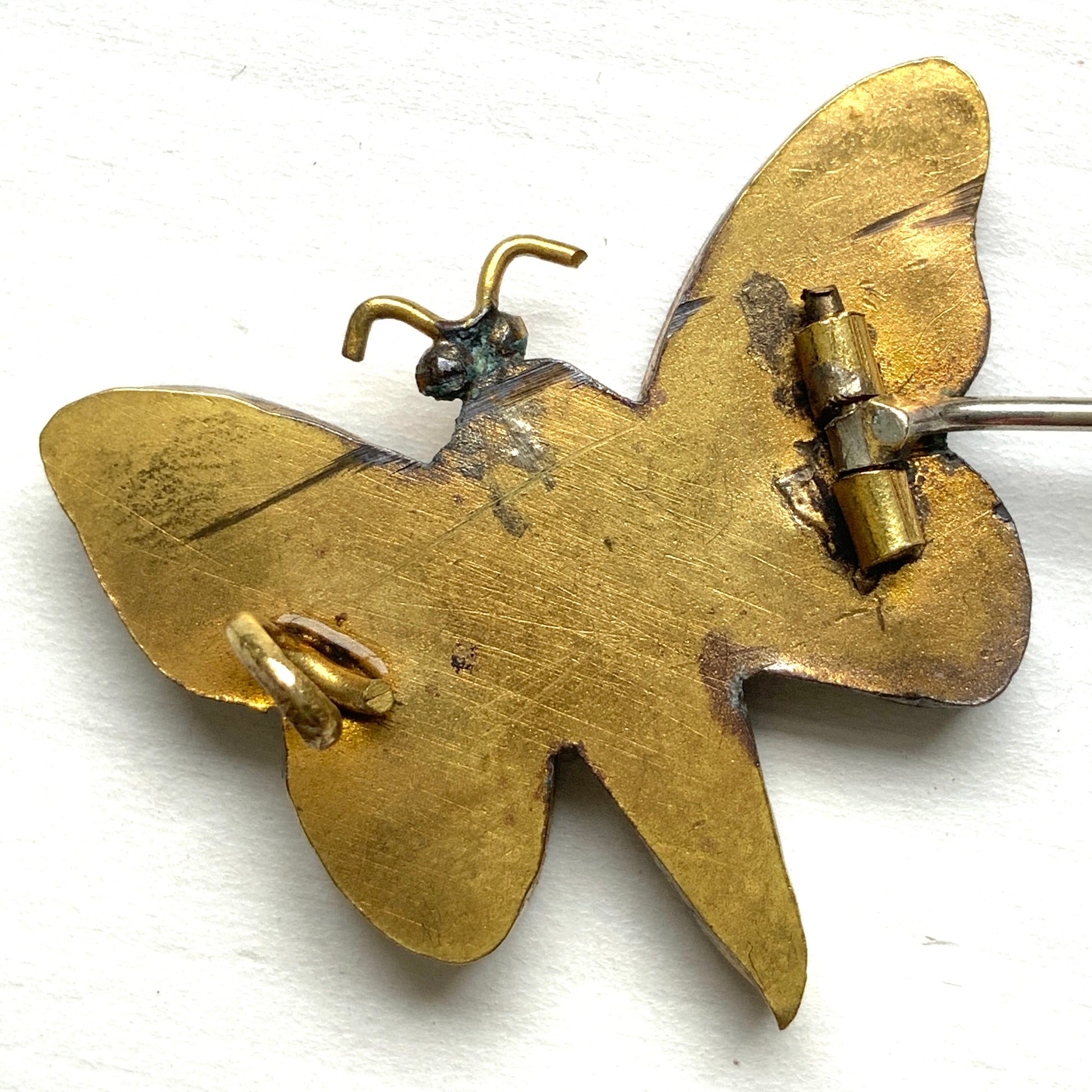 A micro mosaic butterfly brooch featuring delicate floral designs on its wings. お花が羽に入ったマイクロモザイク の蝶々のブローチ。