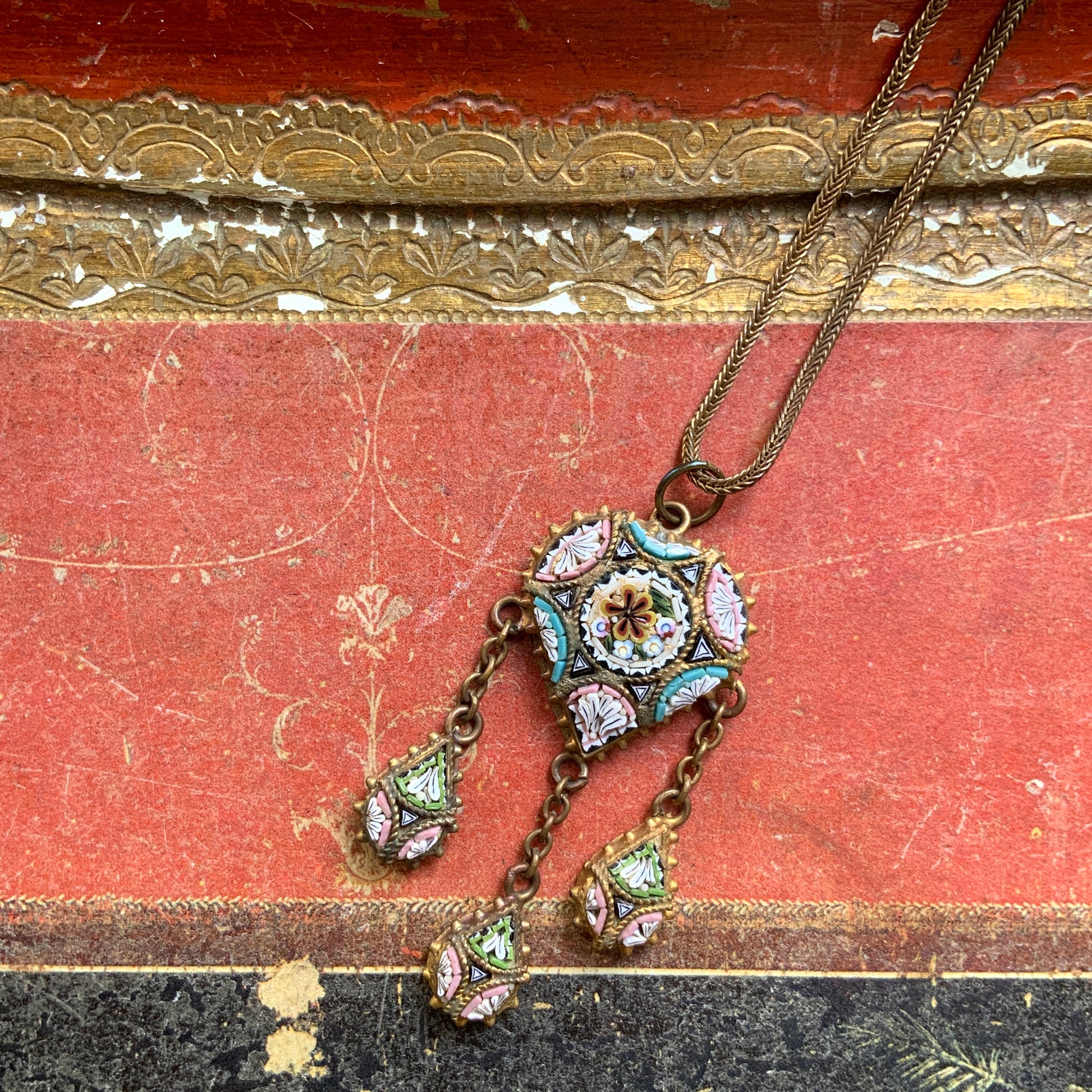 A heart-shaped micro mosaic pendant suspends three delicate teardrop-shaped micro mosaics, forming a beautifully balanced necklace. ハート型のマイクロモザイク から三つのマイクロモザイク ティアドロップが下がったネックレス。