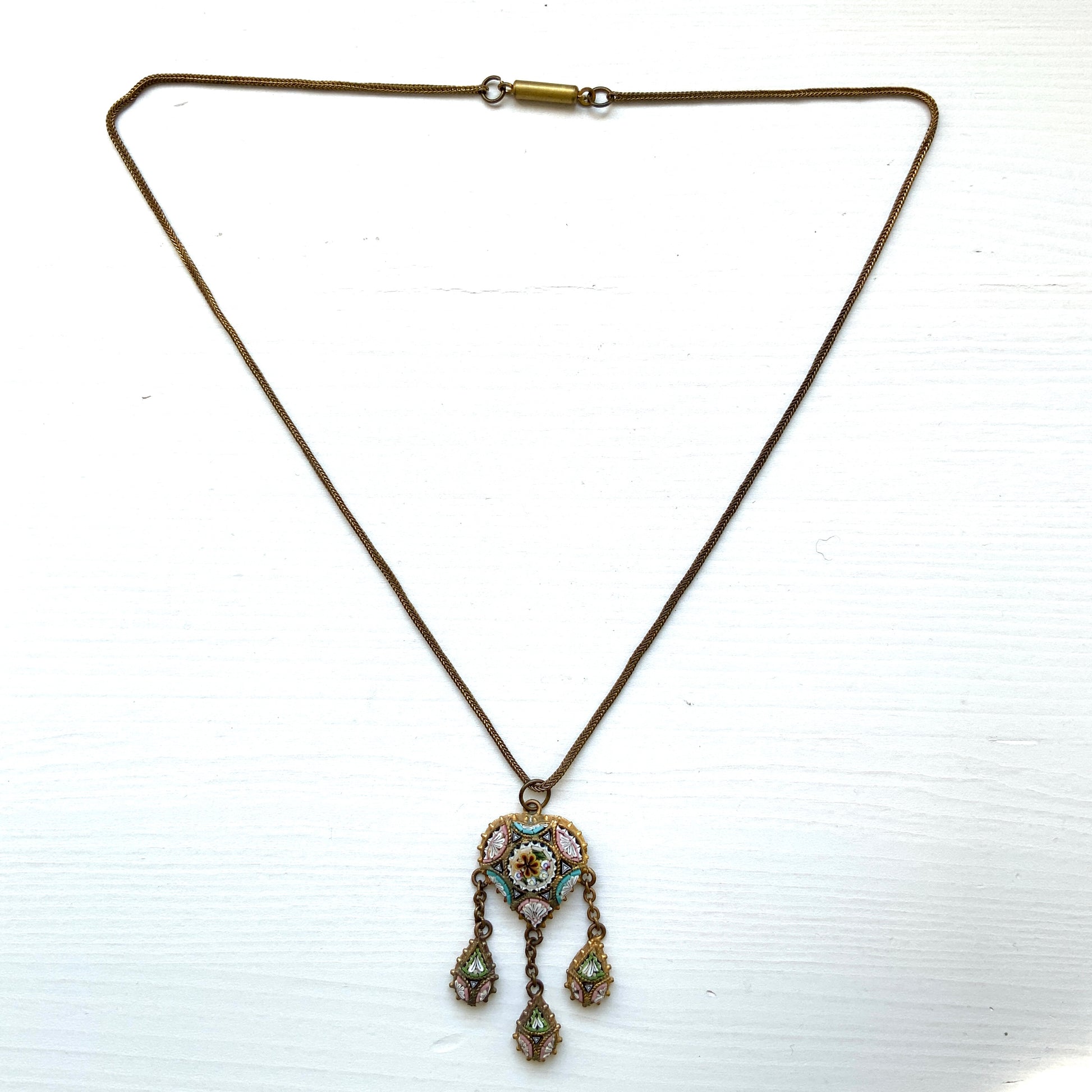 A heart-shaped micro mosaic pendant suspends three delicate teardrop-shaped micro mosaics, forming a beautifully balanced necklace. ハート型のマイクロモザイク から三つのマイクロモザイク ティアドロップが下がったネックレス。