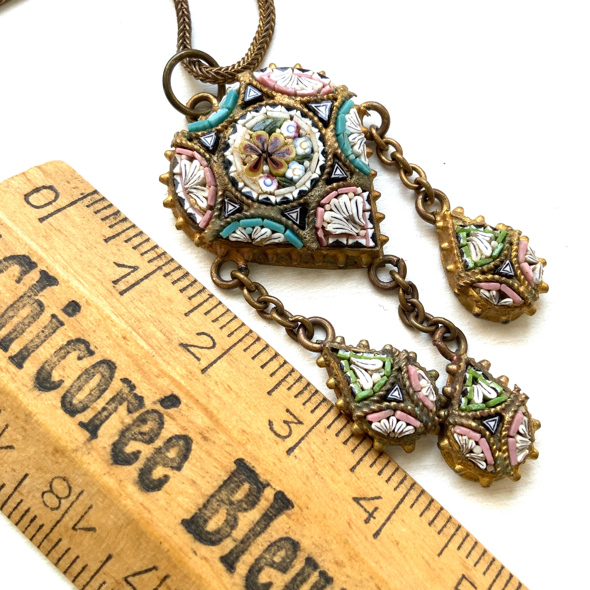 A heart-shaped micro mosaic pendant suspends three delicate teardrop-shaped micro mosaics, forming a beautifully balanced necklace. ハート型のマイクロモザイク から三つのマイクロモザイク ティアドロップが下がったネックレス。