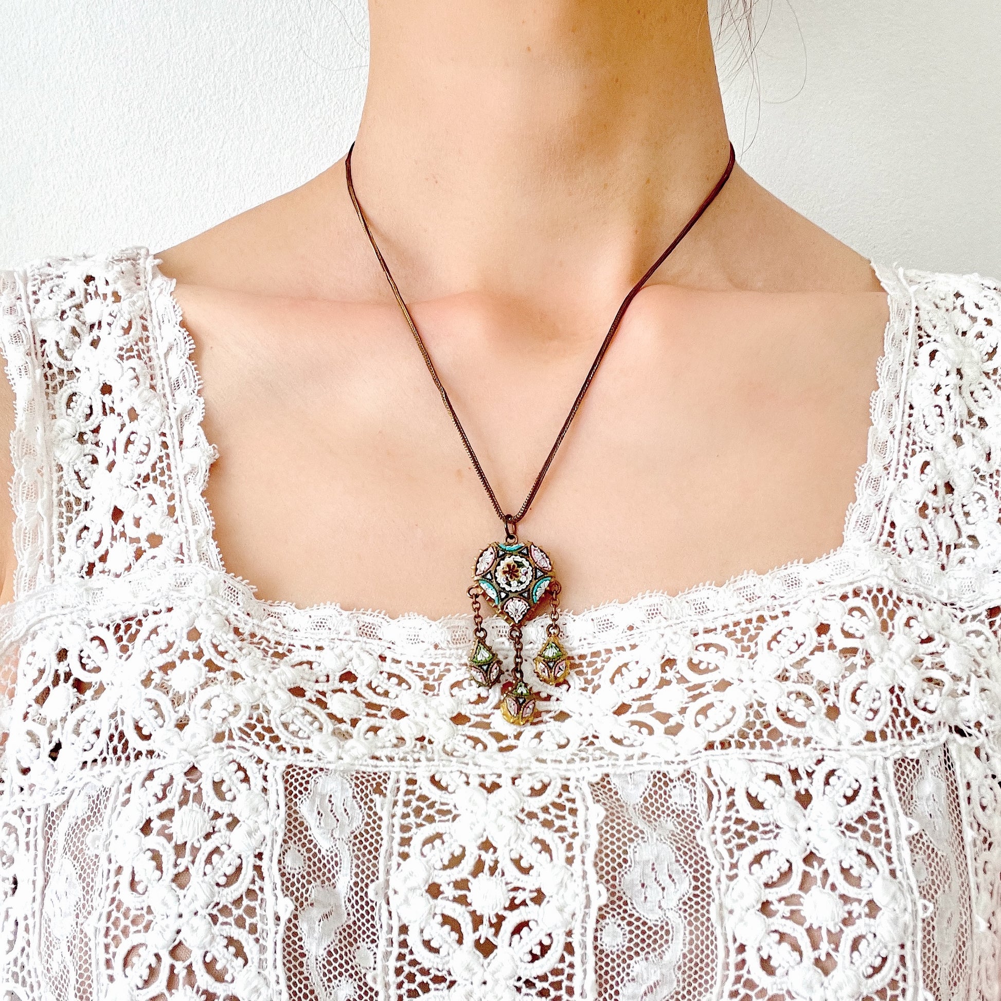 A heart-shaped micro mosaic pendant suspends three delicate teardrop-shaped micro mosaics, forming a beautifully balanced necklace. ハート型のマイクロモザイク から三つのマイクロモザイク ティアドロップが下がったネックレス。