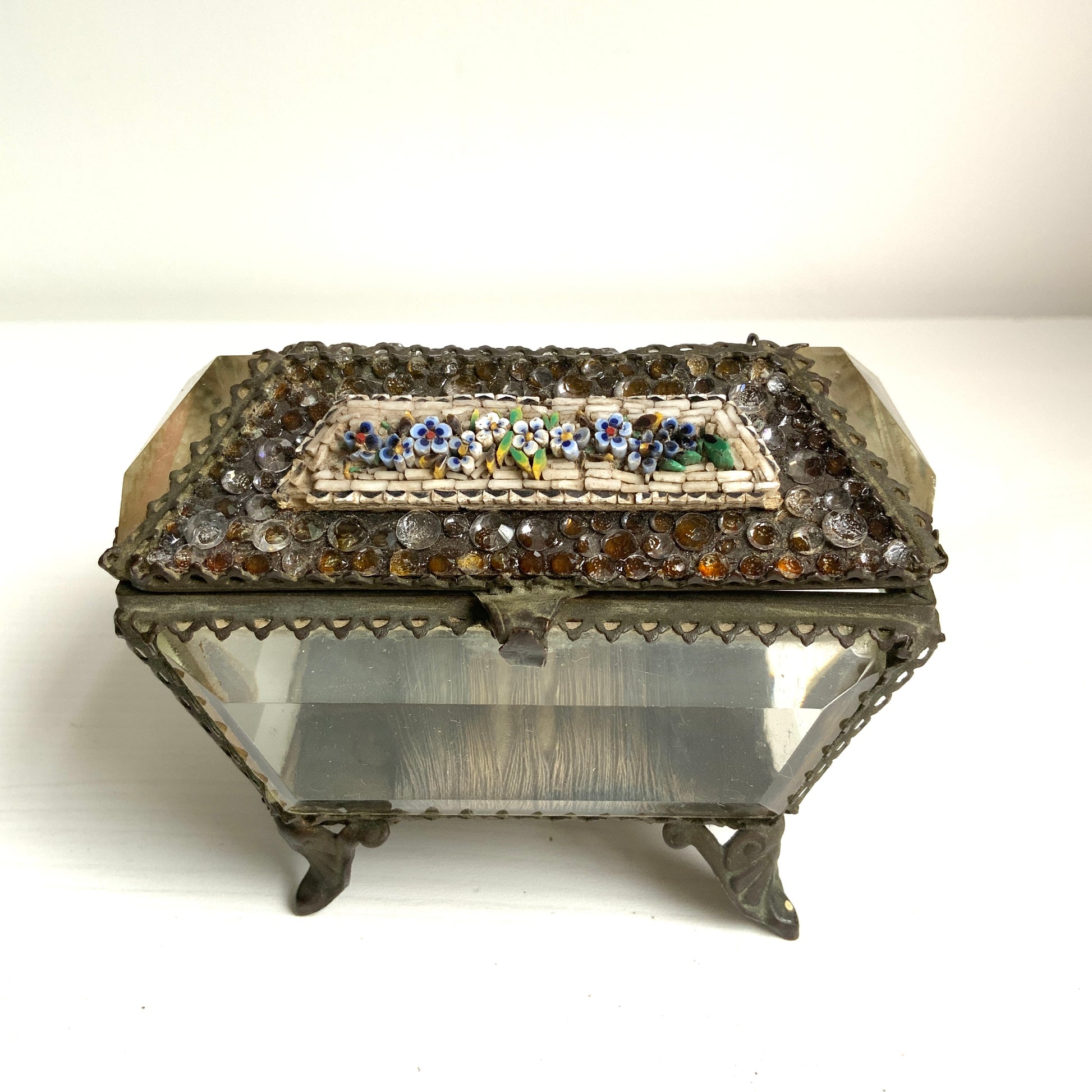 An antique jewelry box made of thick, cut glass—this particular piece is exceptionally rare, featuring both glass stones and micro mosaic detailing on its lid. 厚みのあるカットグラスで作られたアンティークのジュエリーボックス。中でもこちらは、蓋部分にグラスストーンとマイクロモザイクが施された、非常に珍しい一点です。