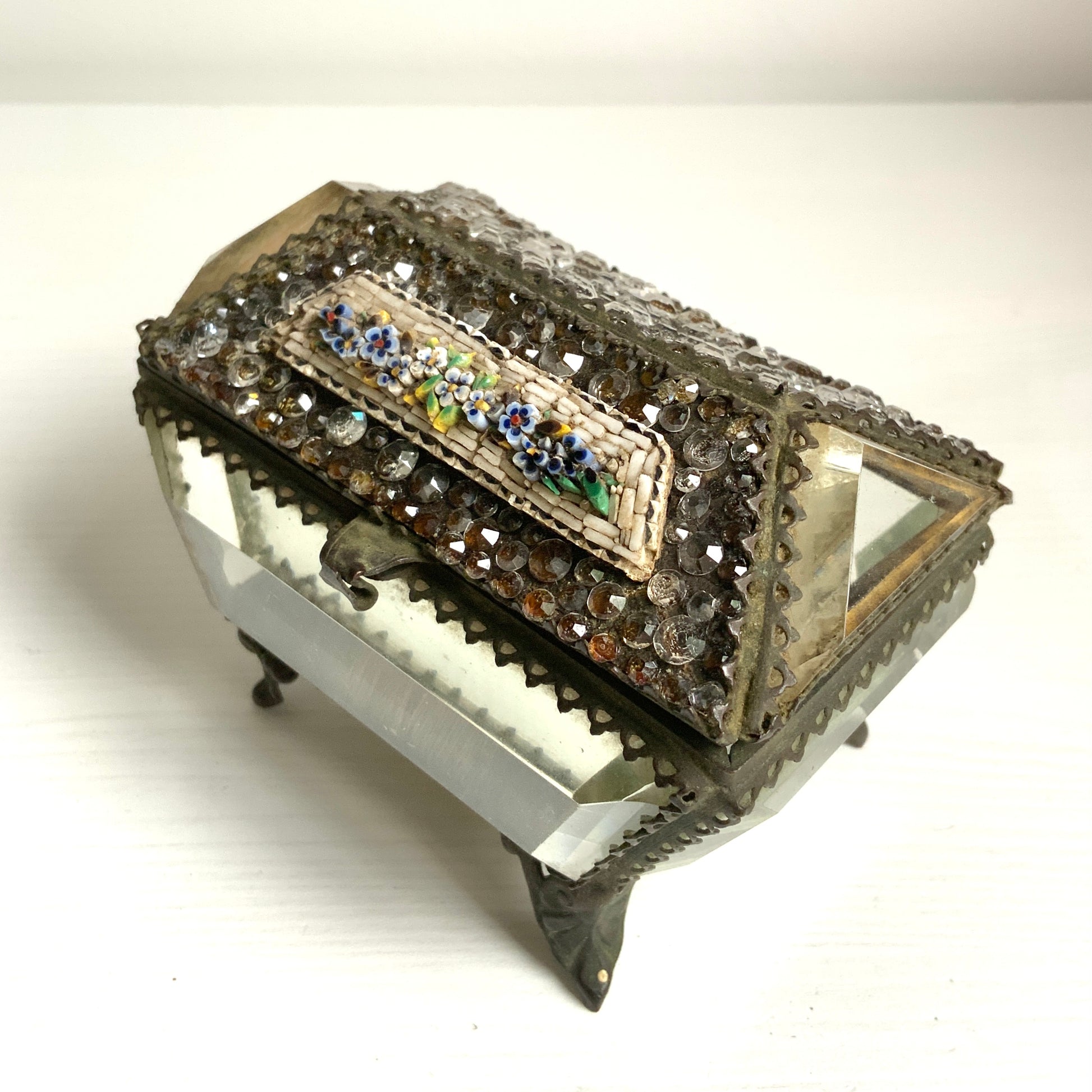 An antique jewelry box made of thick, cut glass—this particular piece is exceptionally rare, featuring both glass stones and micro mosaic detailing on its lid. 厚みのあるカットグラスで作られたアンティークのジュエリーボックス。中でもこちらは、蓋部分にグラスストーンとマイクロモザイクが施された、非常に珍しい一点です。