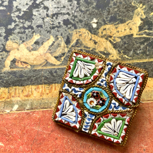 A square-shaped brooch adorned with colorful micro-mosaics. カラフルなマイクロモザイク が施されたスクエア型ブローチ。