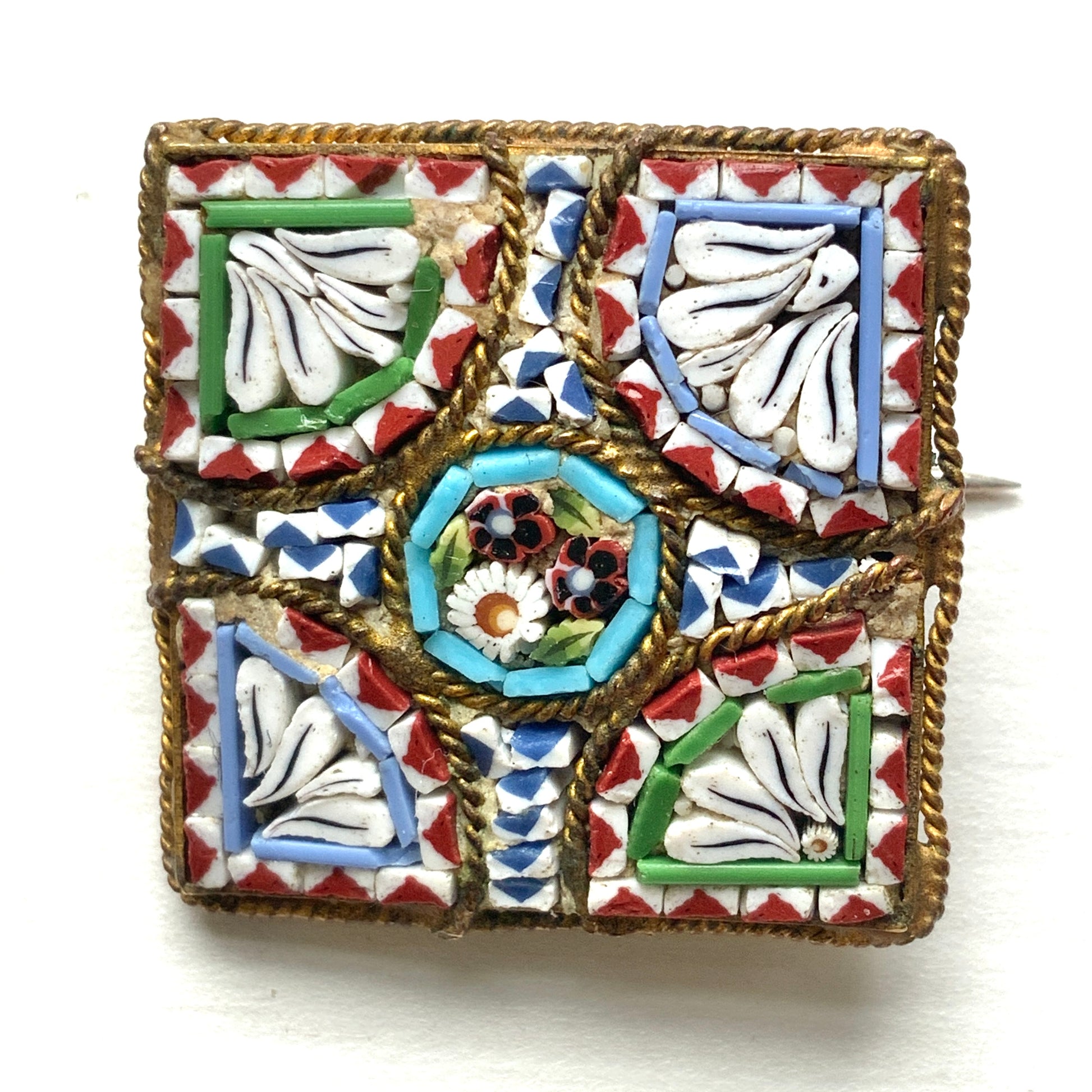 A square-shaped brooch adorned with colorful micro-mosaics. カラフルなマイクロモザイク が施されたスクエア型ブローチ。