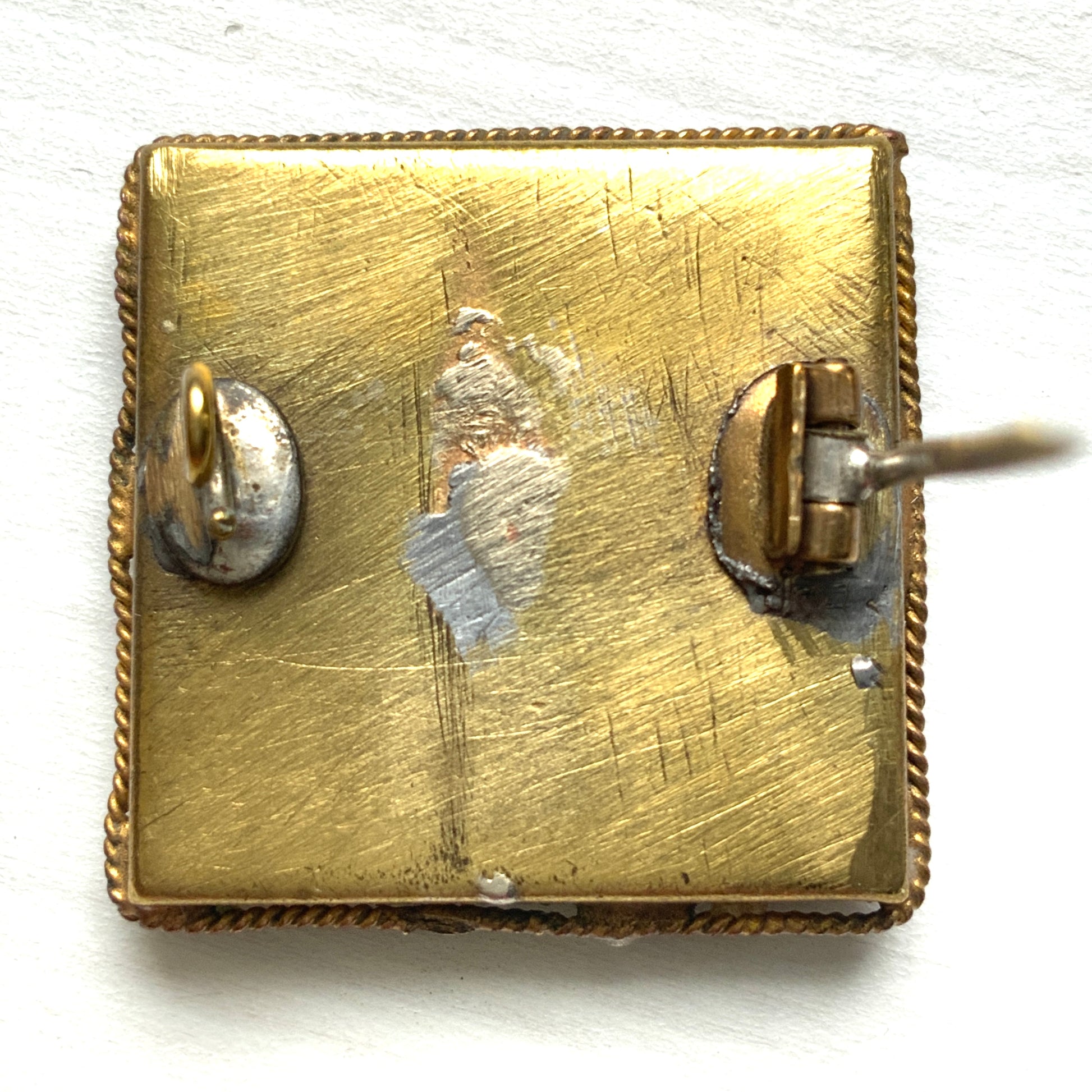A square-shaped brooch adorned with colorful micro-mosaics. カラフルなマイクロモザイク が施されたスクエア型ブローチ。