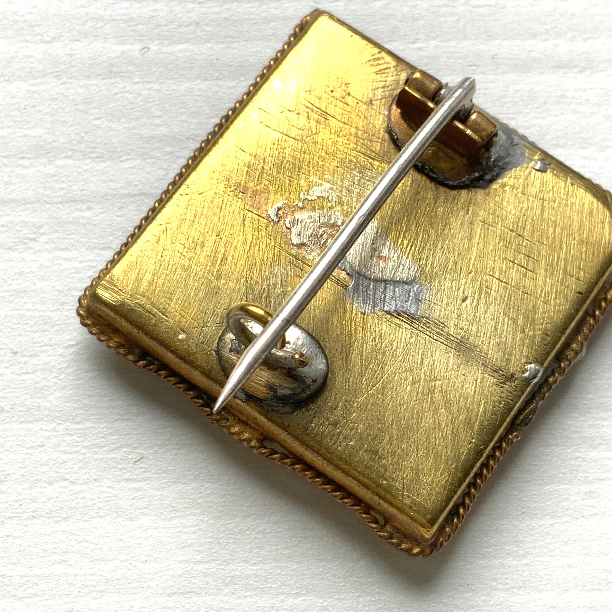 A square-shaped brooch adorned with colorful micro-mosaics. カラフルなマイクロモザイク が施されたスクエア型ブローチ。