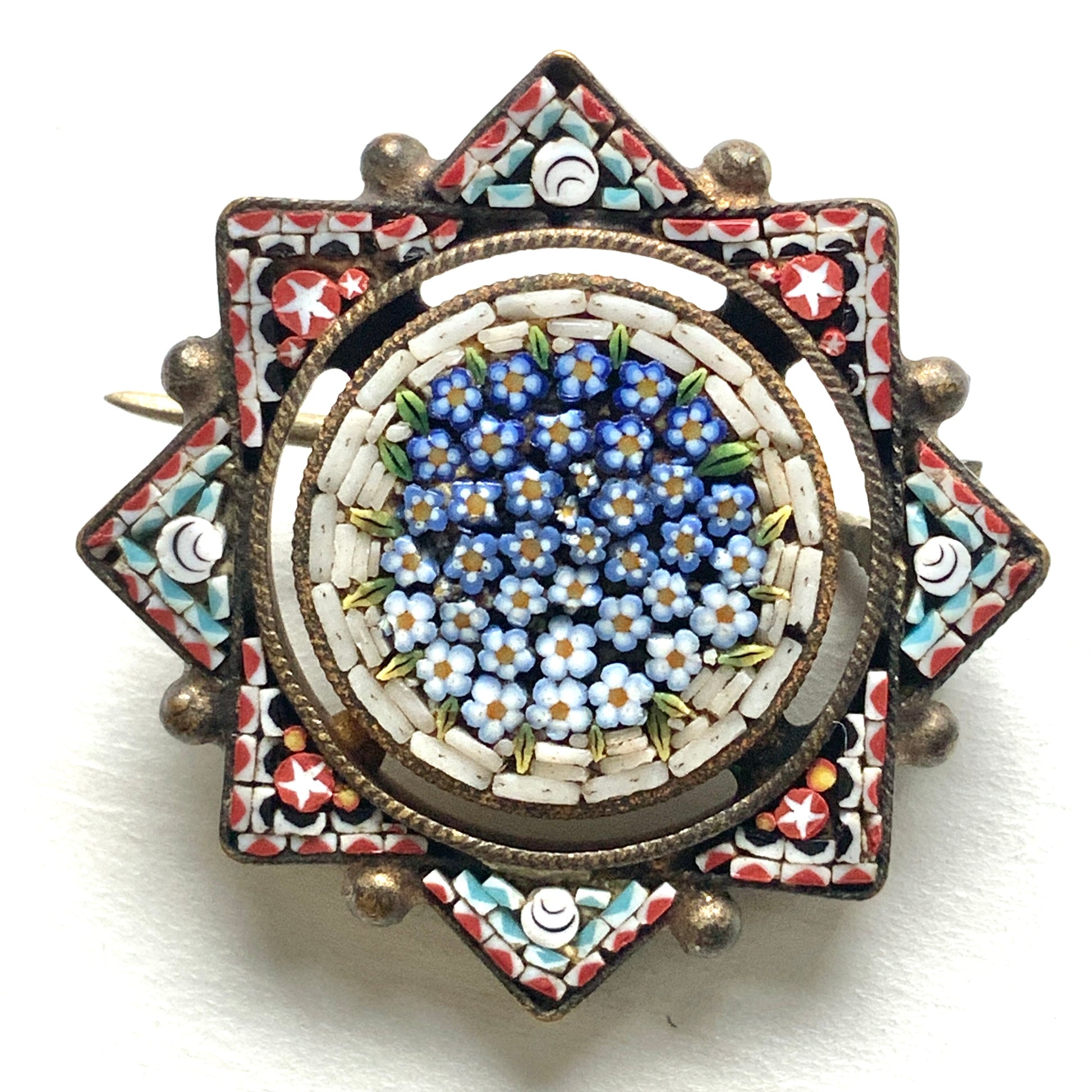 A star-shaped micro mosaic brooch filled with tiny, charming blue flowers reminiscent of forget-me-nots. 勿忘草のような、かわいらしい青い小花がぎっしりと詰め込まれた星型のマイクロモザイクブローチ。