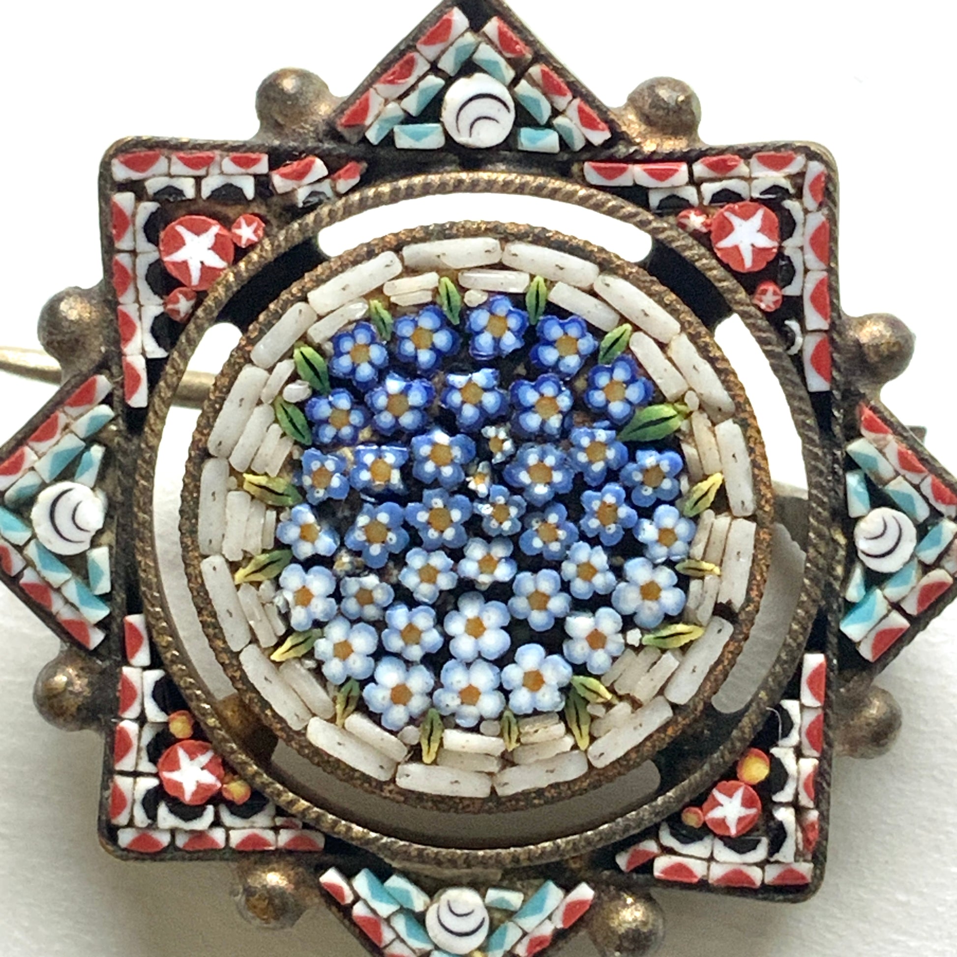A star-shaped micro mosaic brooch filled with tiny, charming blue flowers reminiscent of forget-me-nots. 勿忘草のような、かわいらしい青い小花がぎっしりと詰め込まれた星型のマイクロモザイクブローチ。