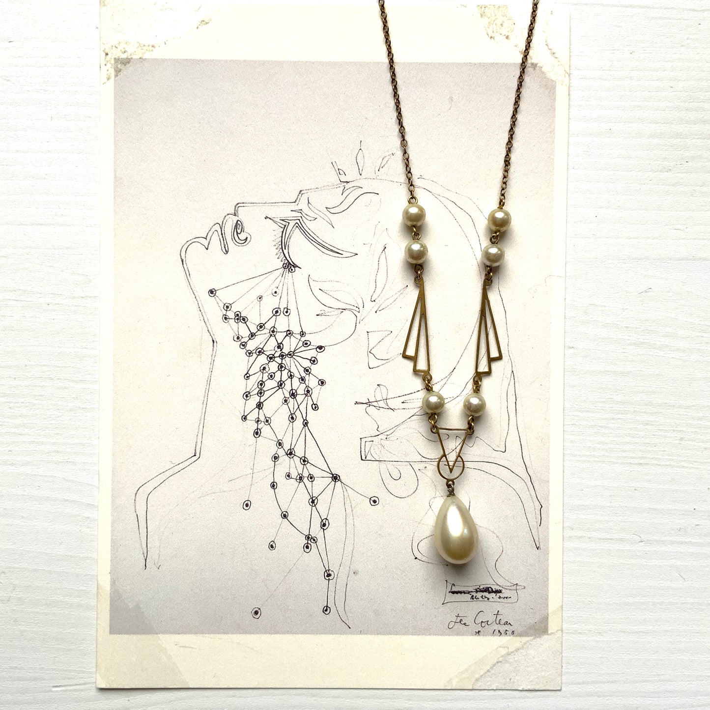 A necklace combining gold-tone metal links and glass pearls. ゴールドトーンメタルのリンクとグラスパールを組み合わせたネックレス。