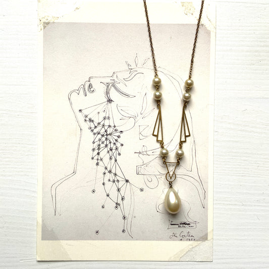A necklace combining gold-tone metal links and glass pearls. ゴールドトーンメタルのリンクとグラスパールを組み合わせたネックレス。