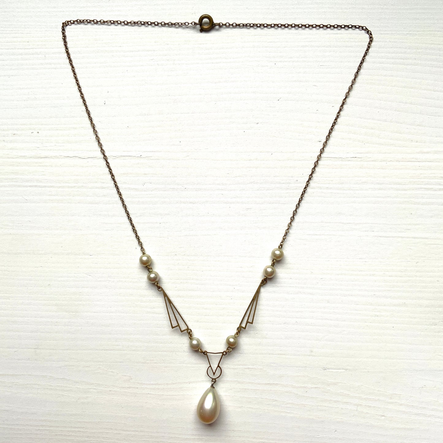 A necklace combining gold-tone metal links and glass pearls. ゴールドトーンメタルのリンクとグラスパールを組み合わせたネックレス。