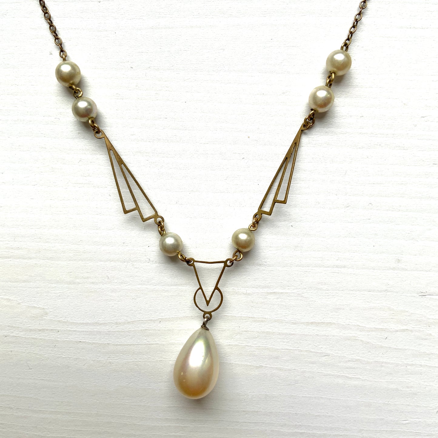 A necklace combining gold-tone metal links and glass pearls. ゴールドトーンメタルのリンクとグラスパールを組み合わせたネックレス。