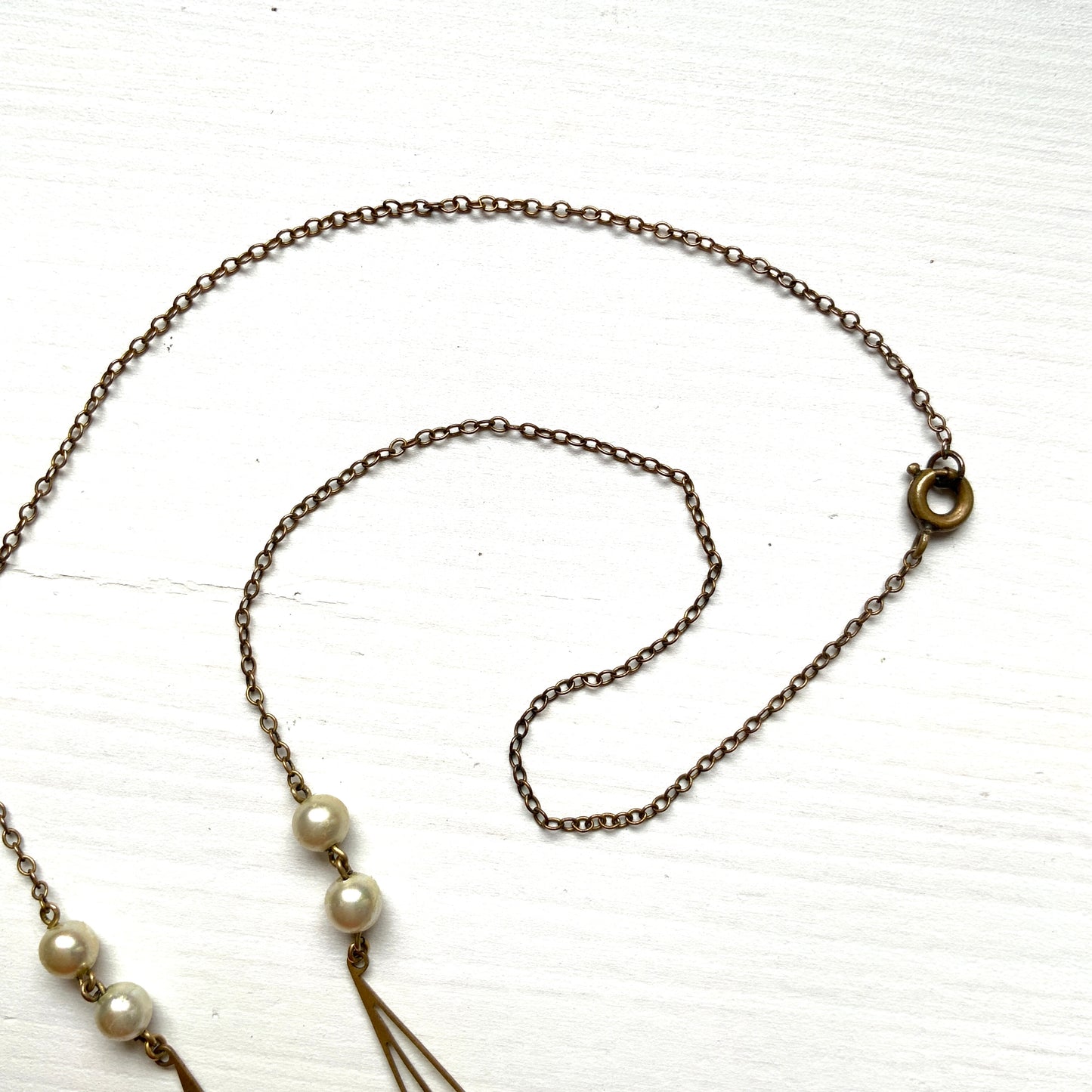 A necklace combining gold-tone metal links and glass pearls. ゴールドトーンメタルのリンクとグラスパールを組み合わせたネックレス。