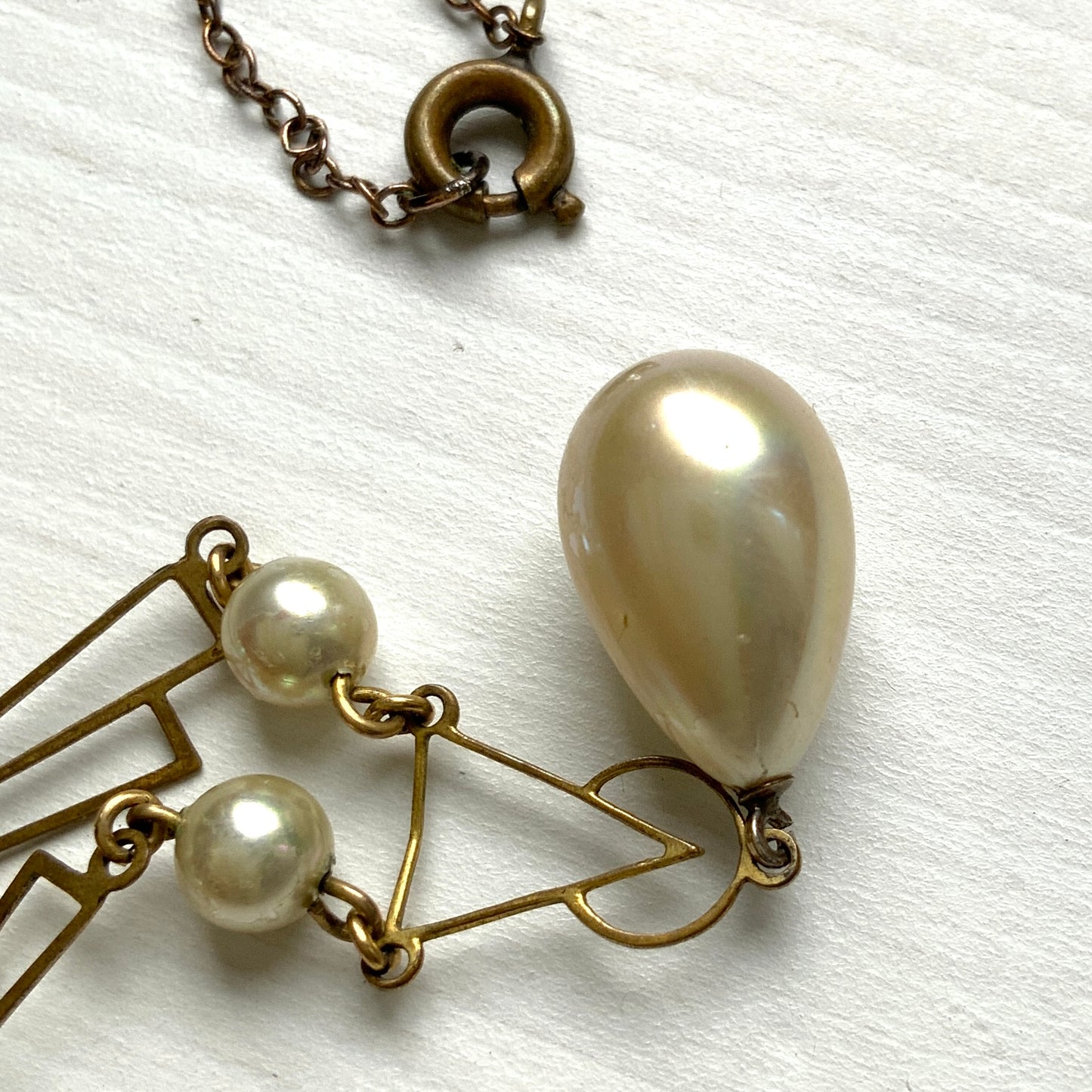 A necklace combining gold-tone metal links and glass pearls. ゴールドトーンメタルのリンクとグラスパールを組み合わせたネックレス。