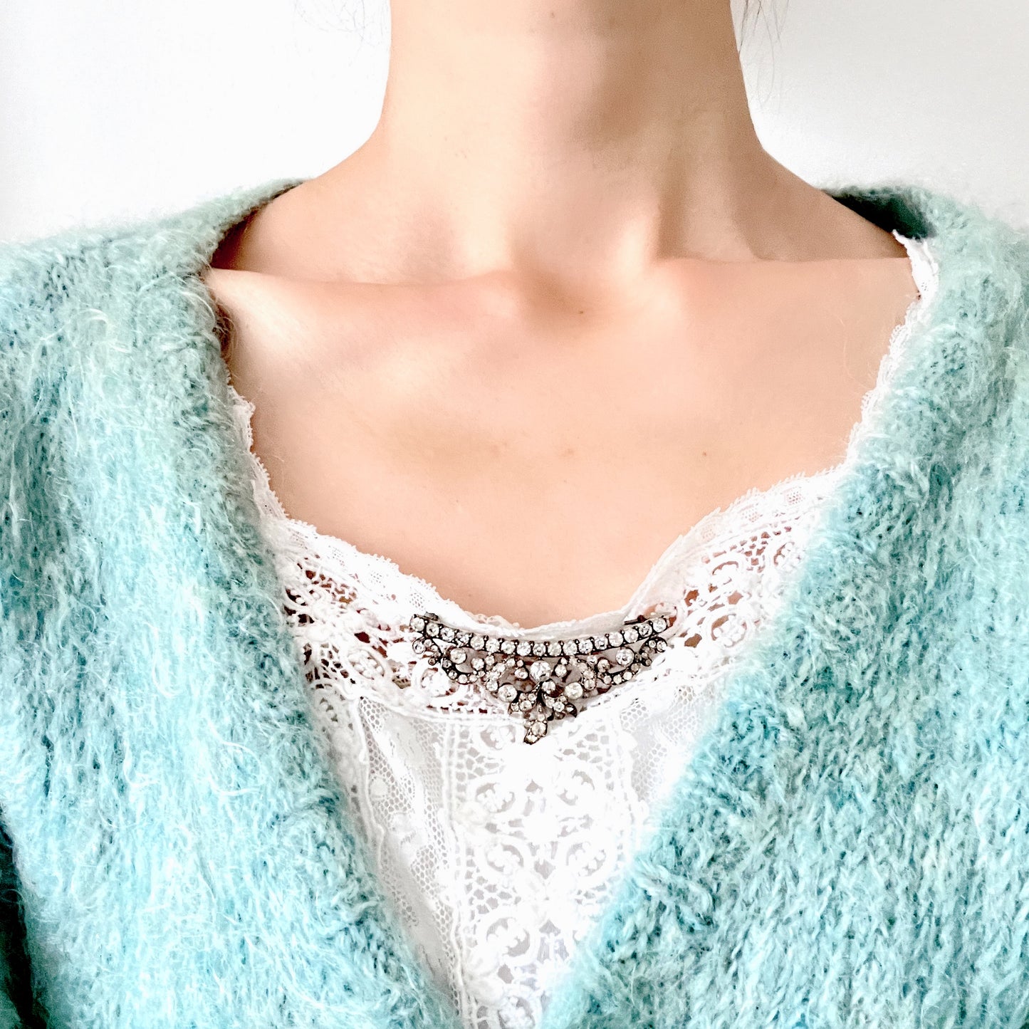 A vintage rhinestone brooch with flowing leaf-like motifs and a gentle curved silhouette. ラインストーンが連なり、葉っぱのようなモチーフがしなやかに広がるヴィンテージブローチ。