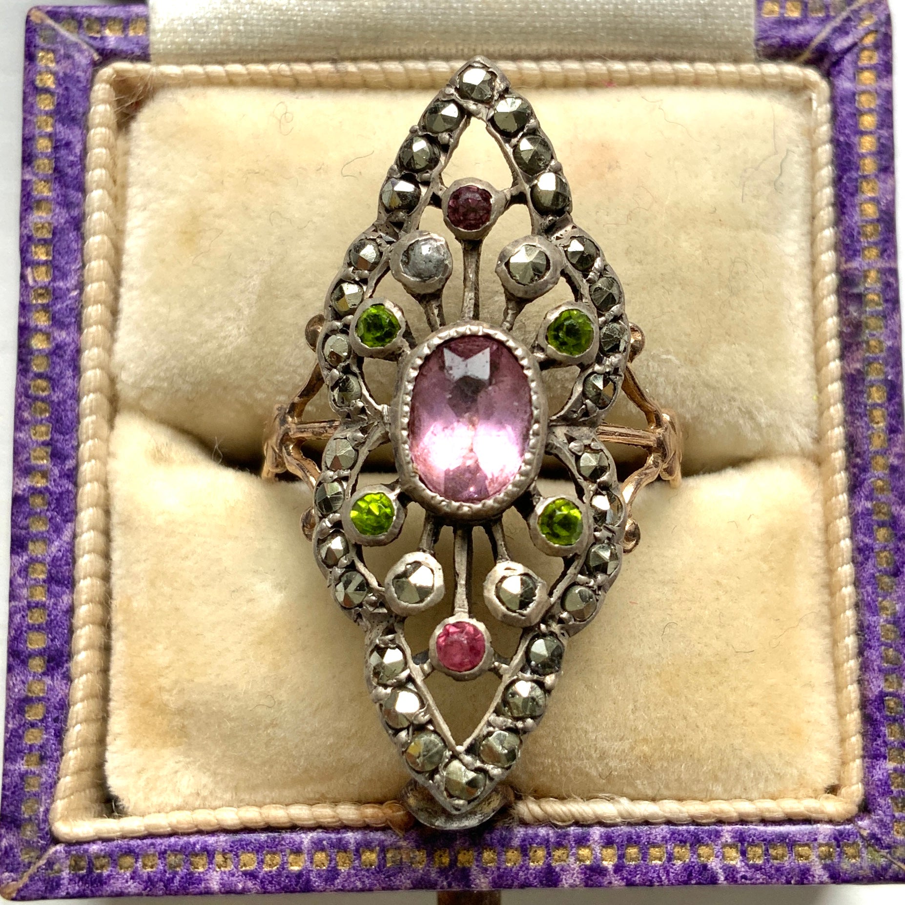 A diamond-shaped ring adorned with amethyst glass, peridot glass, and marcasite. ダイヤモンドシェイプに、アメジストグラス、ペリドットグラス、マーカサイトがあしらわれたリング。