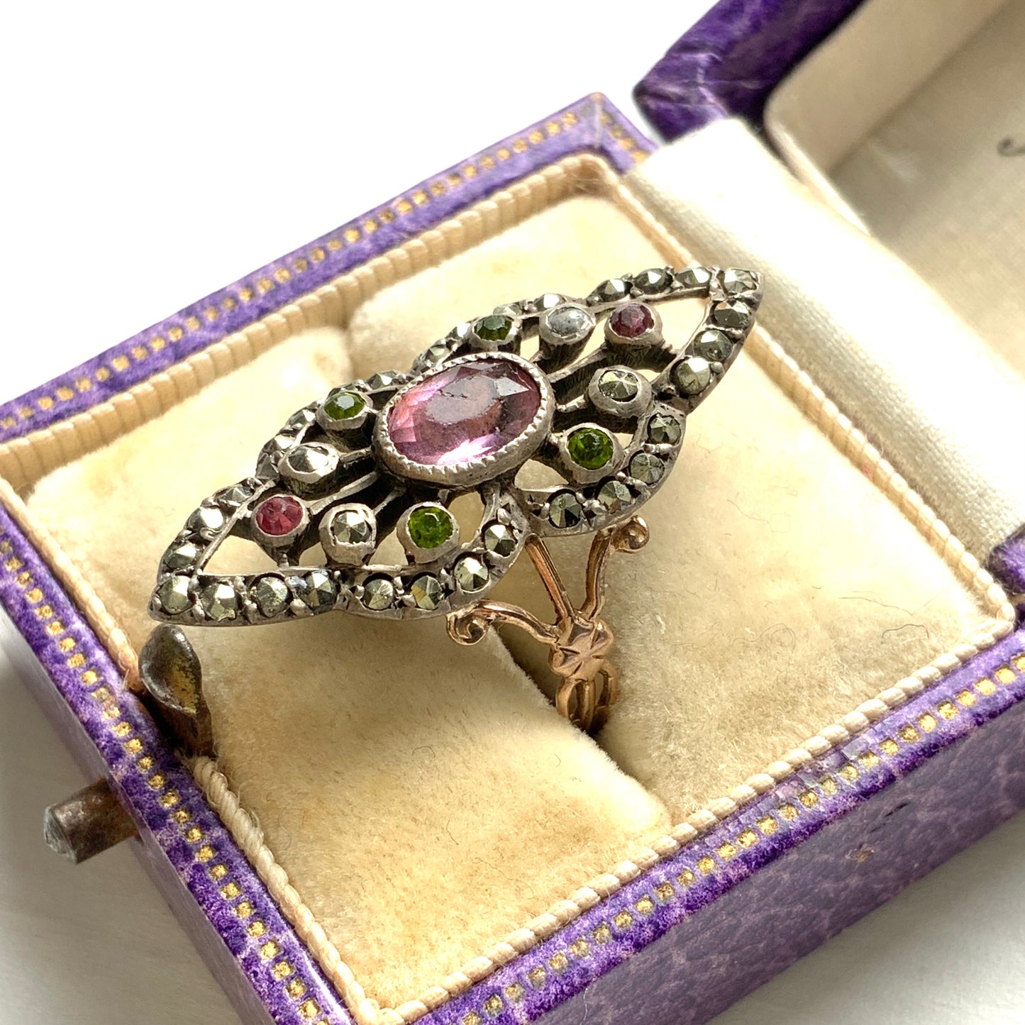 A diamond-shaped ring adorned with amethyst glass, peridot glass, and marcasite. ダイヤモンドシェイプに、アメジストグラス、ペリドットグラス、マーカサイトがあしらわれたリング。