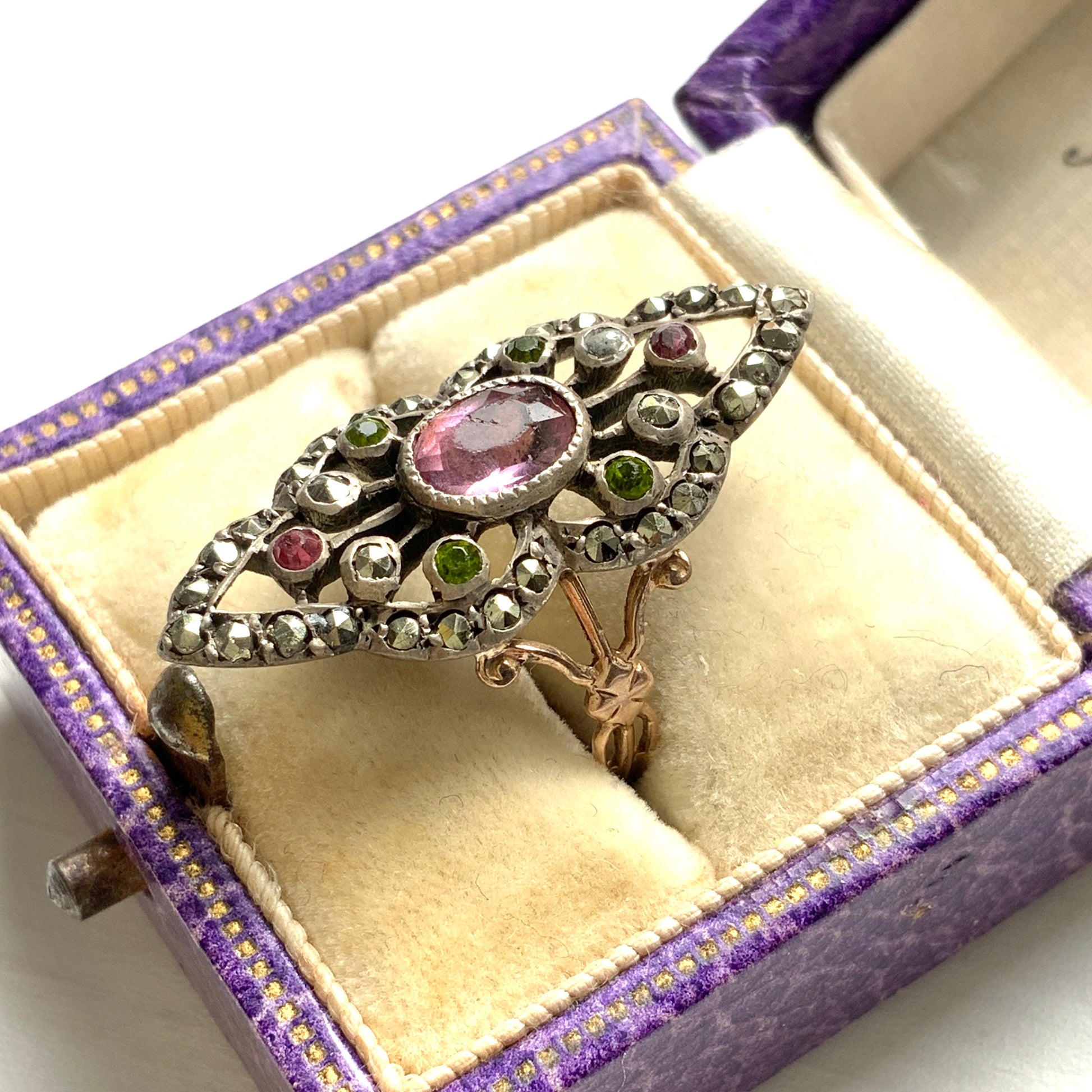 A diamond-shaped ring adorned with amethyst glass, peridot glass, and marcasite. ダイヤモンドシェイプに、アメジストグラス、ペリドットグラス、マーカサイトがあしらわれたリング。