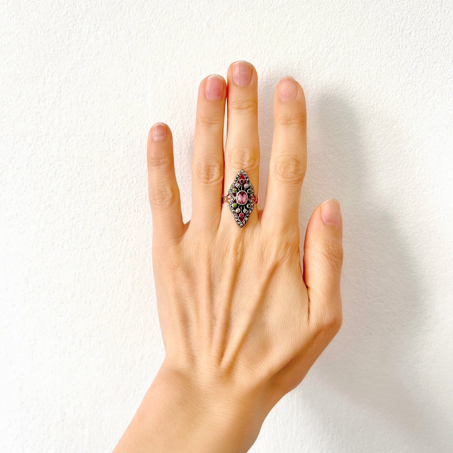 A diamond-shaped ring adorned with amethyst glass, peridot glass, and marcasite. ダイヤモンドシェイプに、アメジストグラス、ペリドットグラス、マーカサイトがあしらわれたリング。