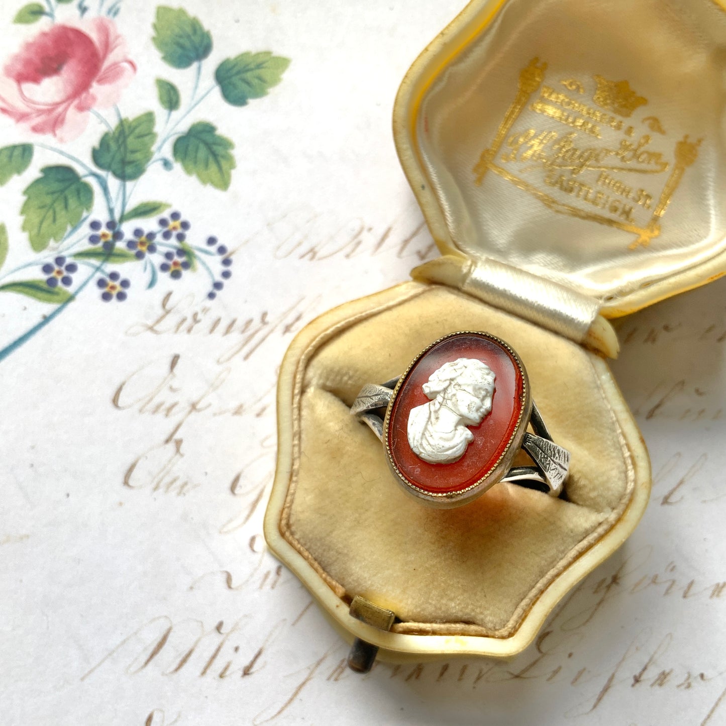 A Victorian ring with a cameo composed of a red glass base and a white porcelain overlay, imitating the look of carnelian two-layer stone. カーネリアンの二層石のカメオを、赤いガラスのベースと白い陶器のカメオで再現したヴィクトリア時代のリング。