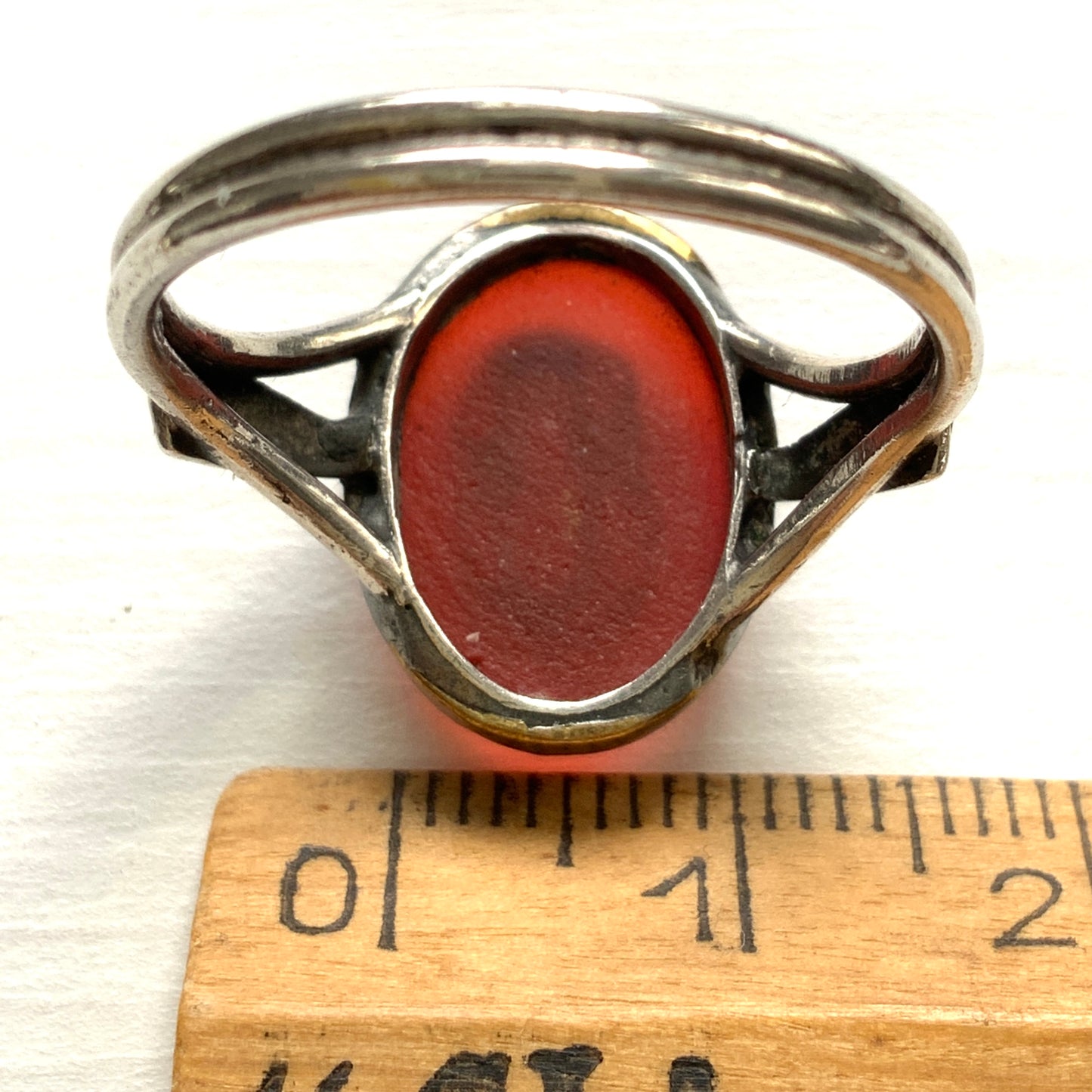A Victorian ring with a cameo composed of a red glass base and a white porcelain overlay, imitating the look of carnelian two-layer stone. カーネリアンの二層石のカメオを、赤いガラスのベースと白い陶器のカメオで再現したヴィクトリア時代のリング。
