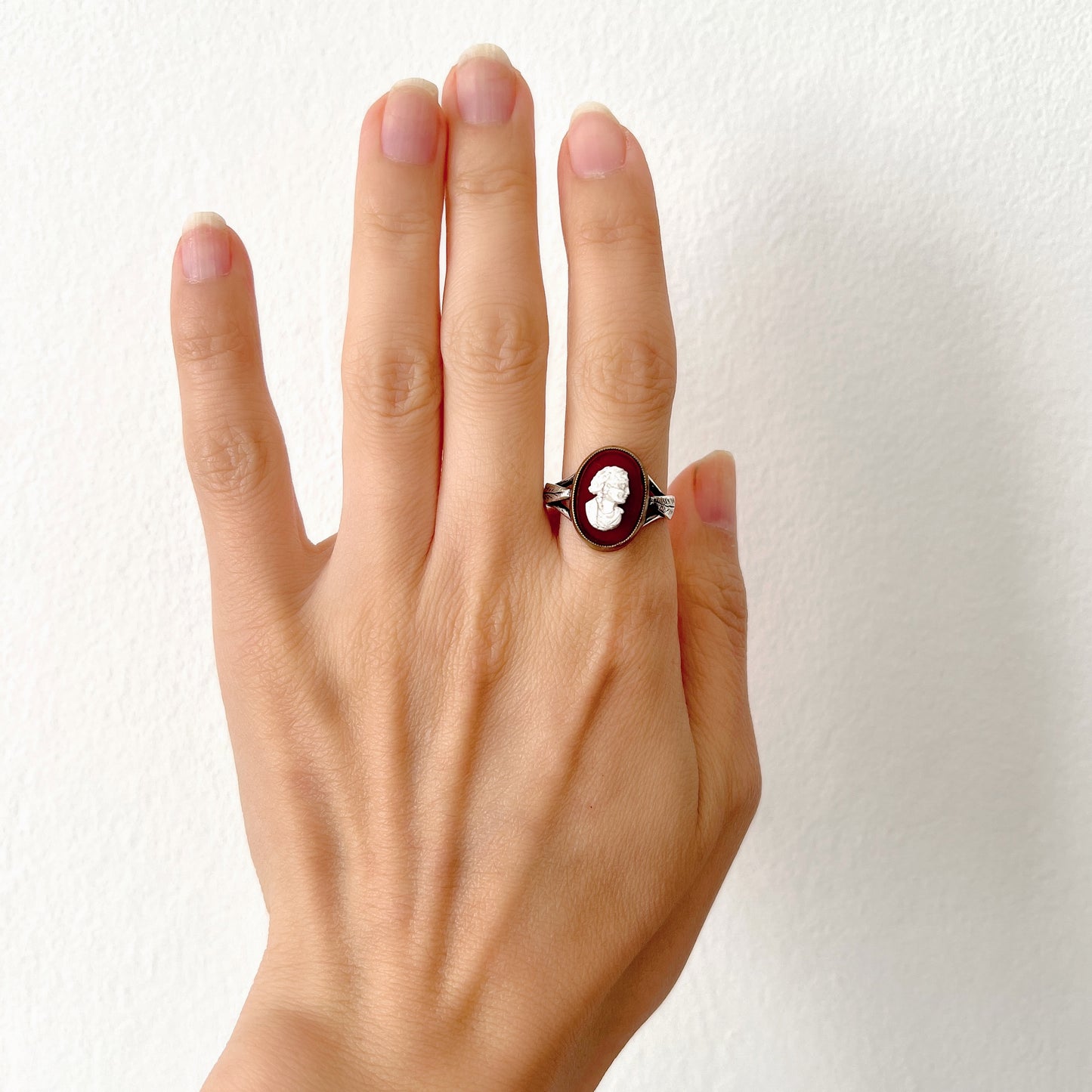 A Victorian ring with a cameo composed of a red glass base and a white porcelain overlay, imitating the look of carnelian two-layer stone. カーネリアンの二層石のカメオを、赤いガラスのベースと白い陶器のカメオで再現したヴィクトリア時代のリング。