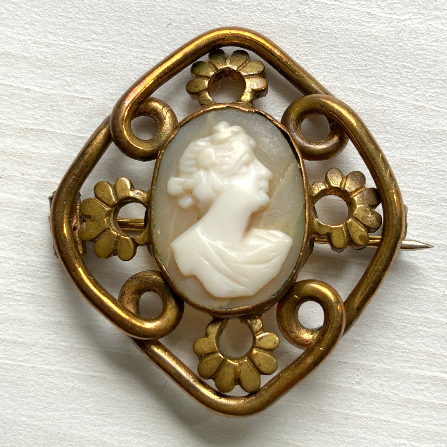 A brooch set with a small shell cameo within a beautiful openwork frame. 美しいオープンワークのフレームに、小さなシェルカメオを収めたブローチ。