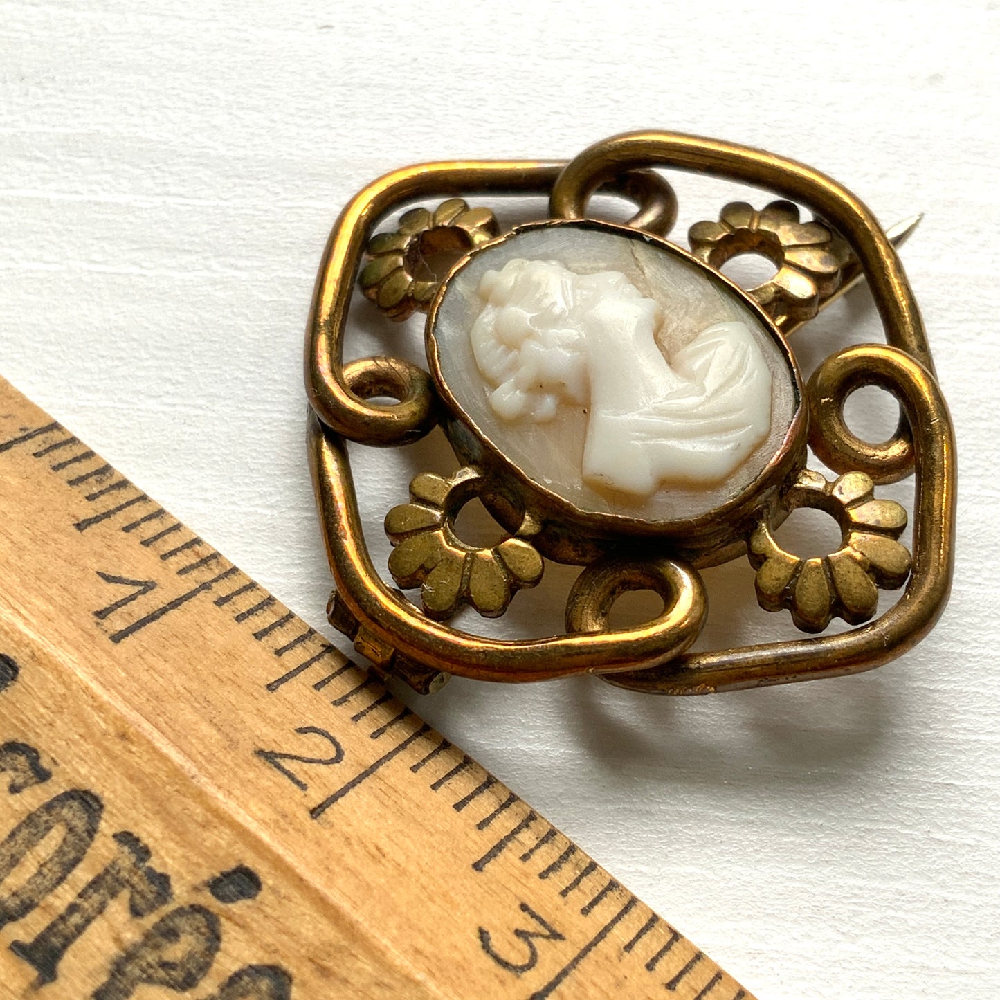 A brooch set with a small shell cameo within a beautiful openwork frame. 美しいオープンワークのフレームに、小さなシェルカメオを収めたブローチ。