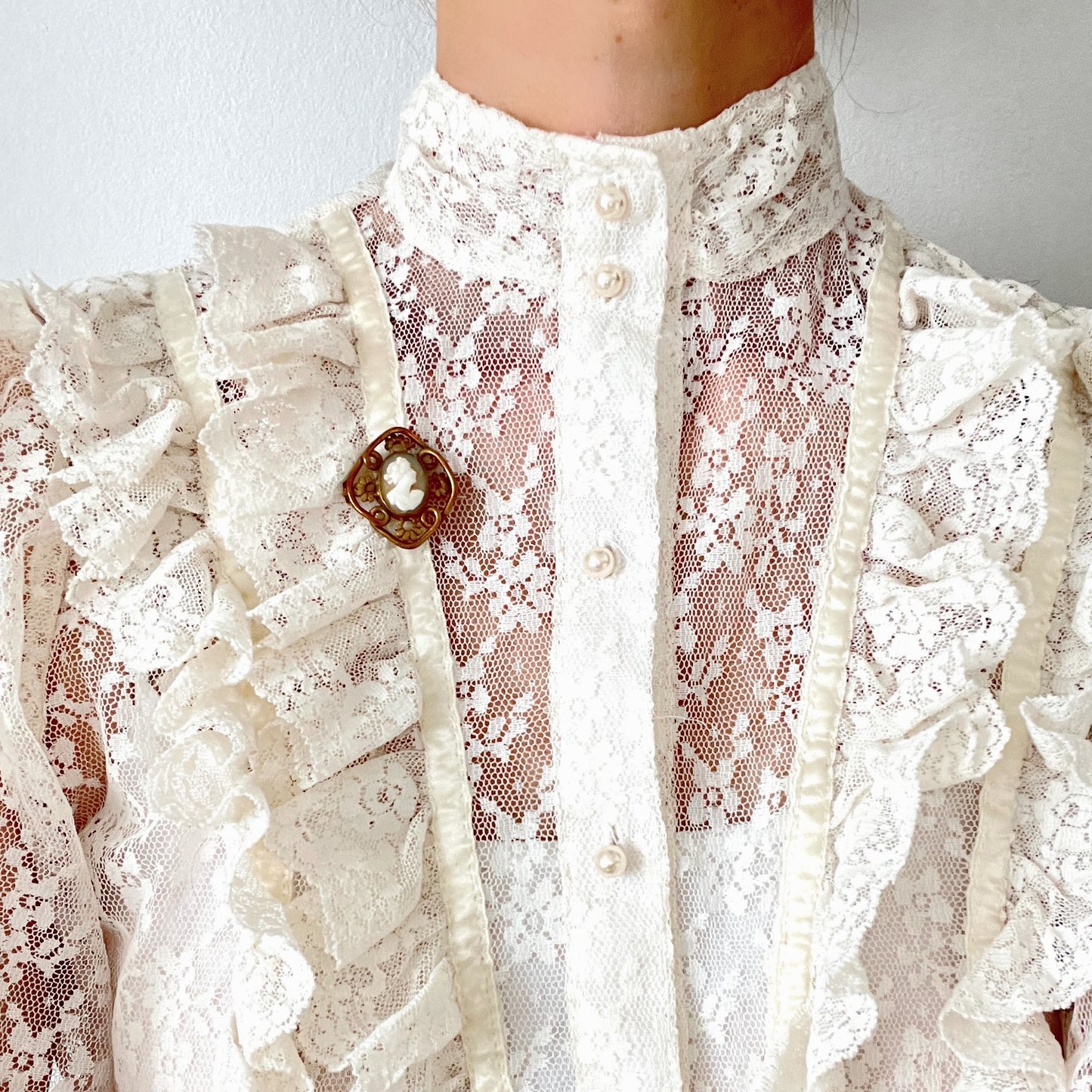 A brooch set with a small shell cameo within a beautiful openwork frame. 美しいオープンワークのフレームに、小さなシェルカメオを収めたブローチ。