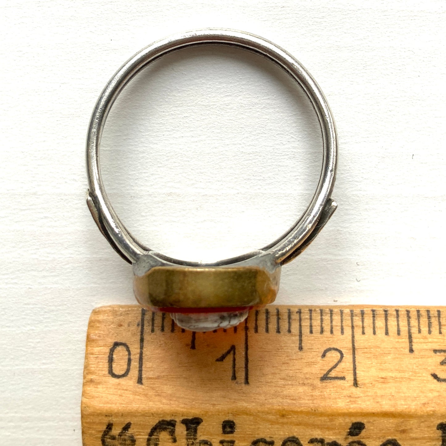 A Victorian ring with a cameo composed of a red glass base and a white porcelain overlay, imitating the look of carnelian two-layer stone. カーネリアンの二層石のカメオを、赤いガラスのベースと白い陶器のカメオで再現したヴィクトリア時代のリング。