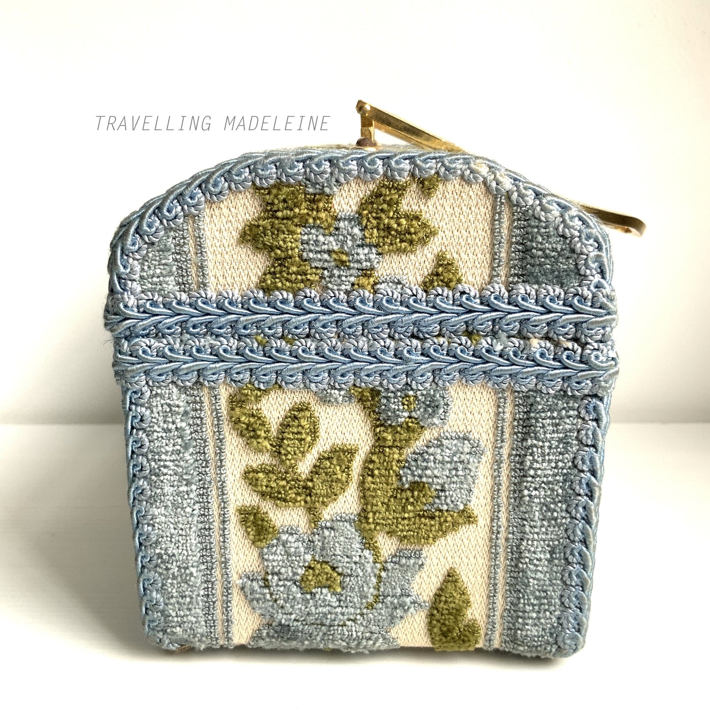 A charming box bag adorned with blue chenille fabric featuring lovely little flowers. ブルーのかわいらしいお花のシェニール生地が貼られたボックスバッグ。