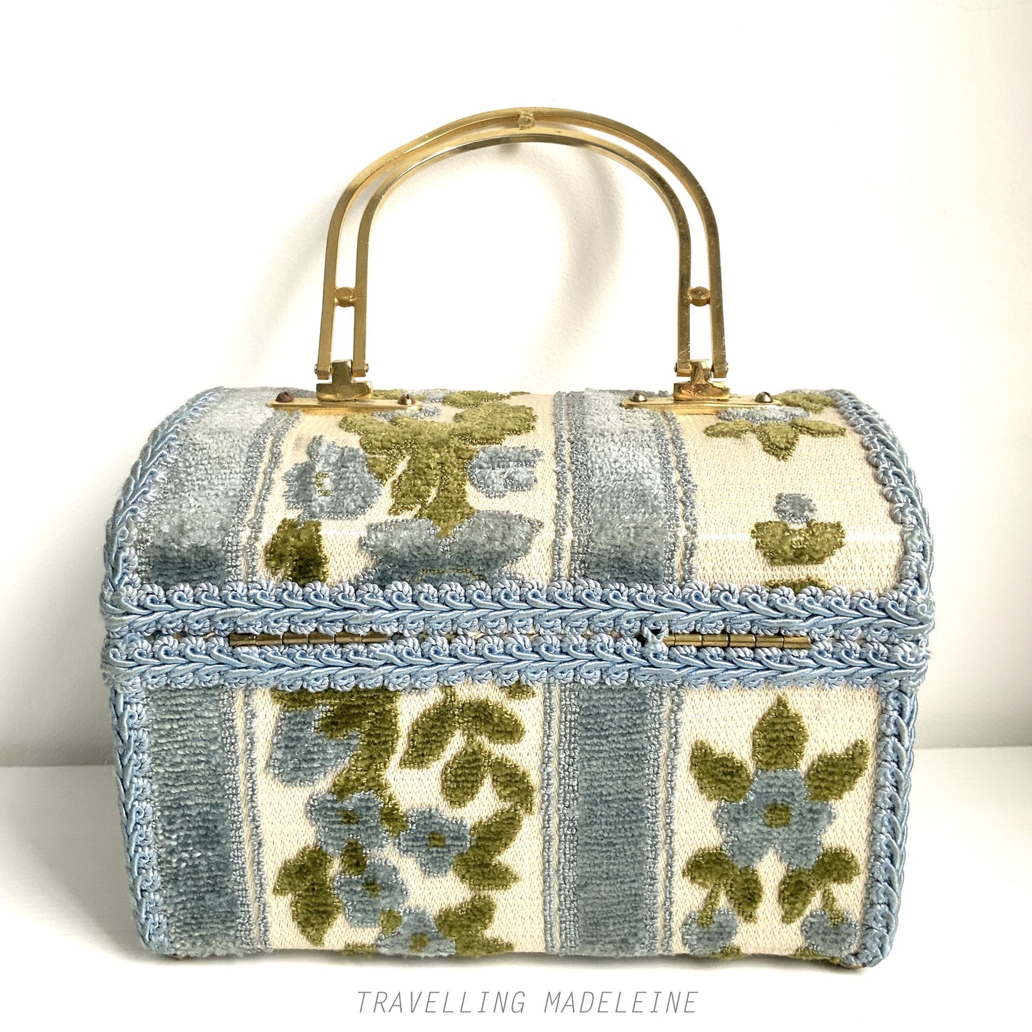 A charming box bag adorned with blue chenille fabric featuring lovely little flowers. ブルーのかわいらしいお花のシェニール生地が貼られたボックスバッグ。