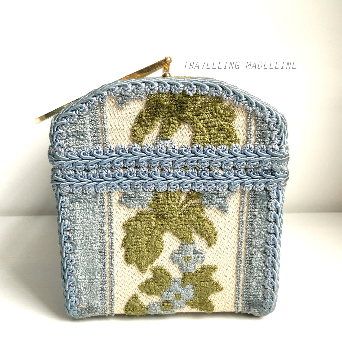 A charming box bag adorned with blue chenille fabric featuring lovely little flowers. ブルーのかわいらしいお花のシェニール生地が貼られたボックスバッグ。