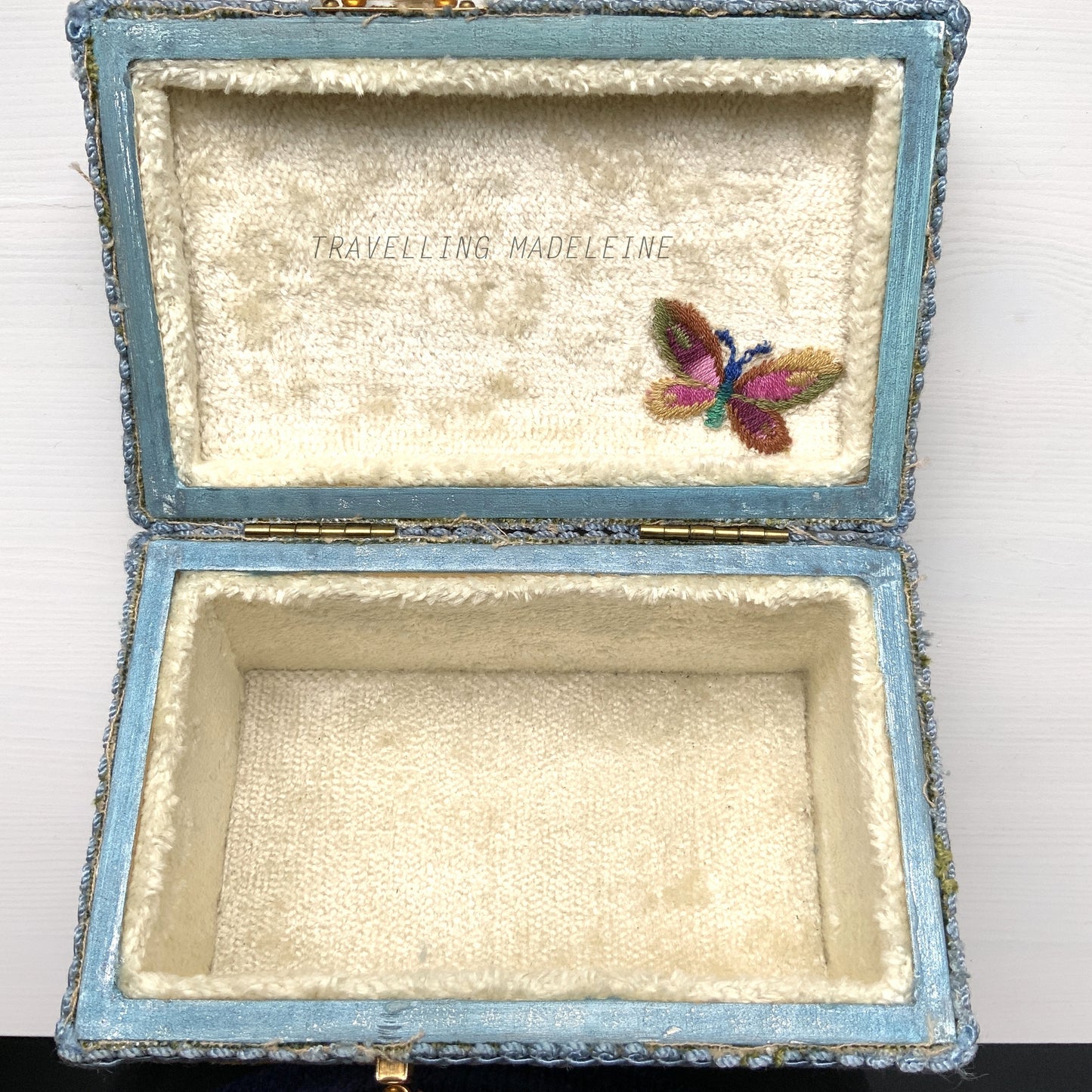 A charming box bag adorned with blue chenille fabric featuring lovely little flowers. ブルーのかわいらしいお花のシェニール生地が貼られたボックスバッグ。