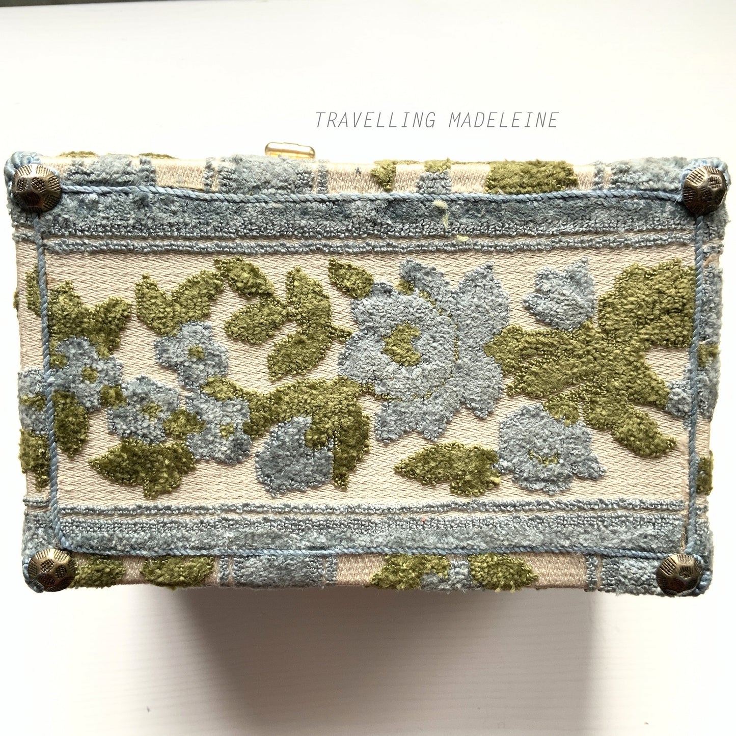 A charming box bag adorned with blue chenille fabric featuring lovely little flowers. ブルーのかわいらしいお花のシェニール生地が貼られたボックスバッグ。