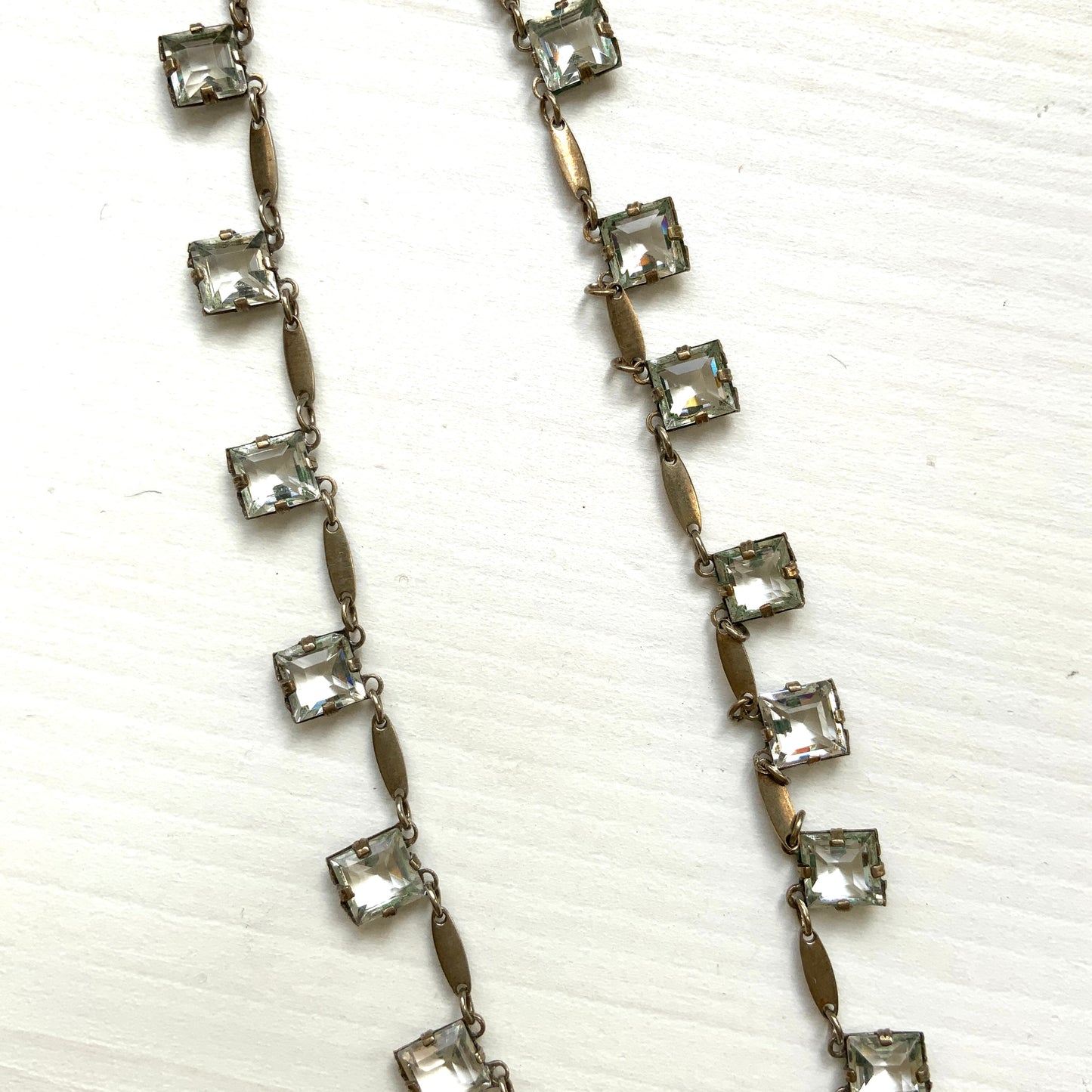 A classic Art Deco silver necklace set with square-cut clear glass stones. クラシックなスクエアカットのクリアグラスが並ぶ、アールデコのシルバーネックレス。