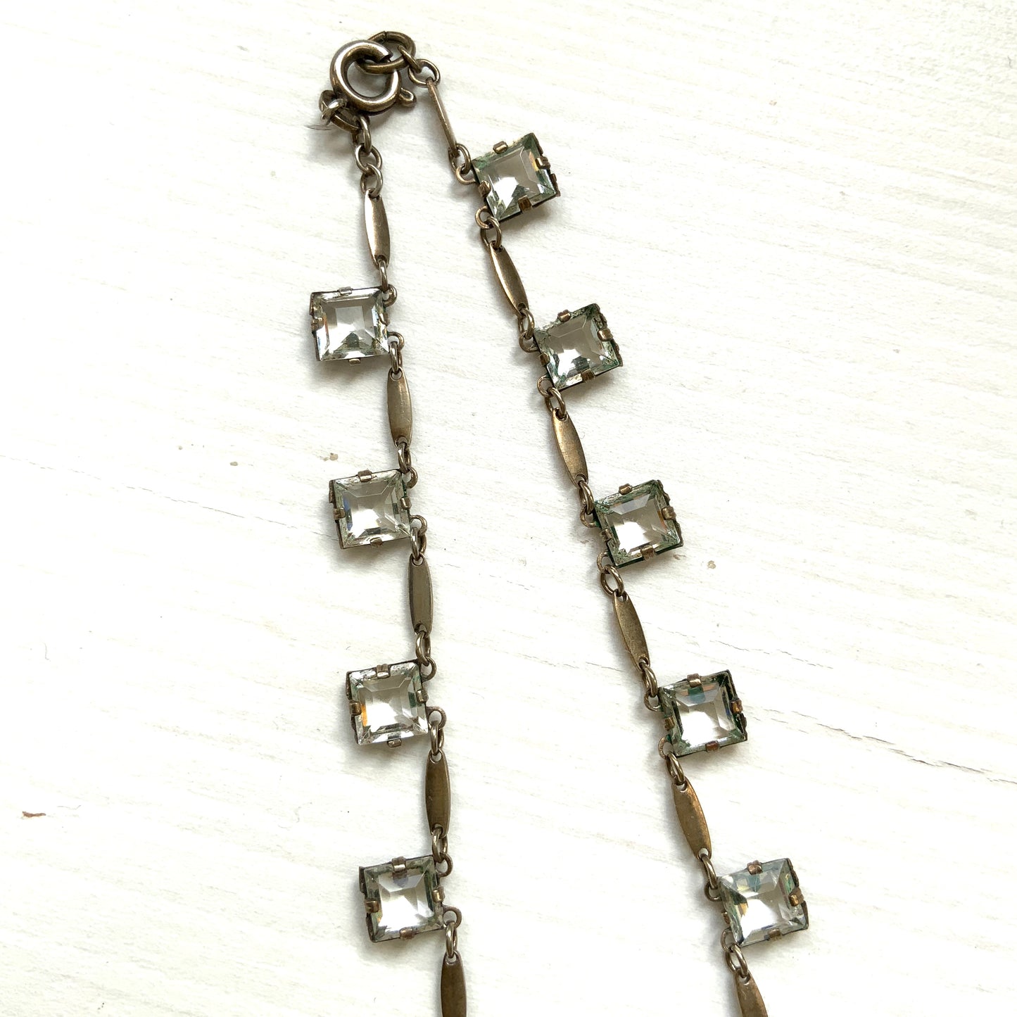 A classic Art Deco silver necklace set with square-cut clear glass stones. クラシックなスクエアカットのクリアグラスが並ぶ、アールデコのシルバーネックレス。