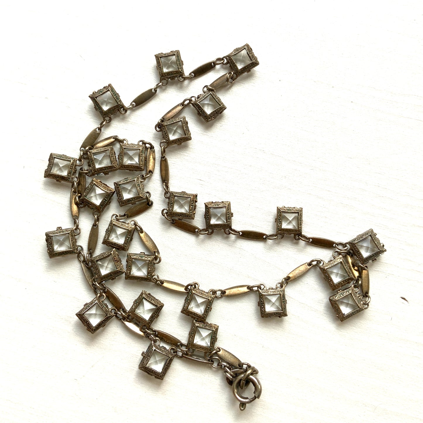 A classic Art Deco silver necklace set with square-cut clear glass stones. クラシックなスクエアカットのクリアグラスが並ぶ、アールデコのシルバーネックレス。