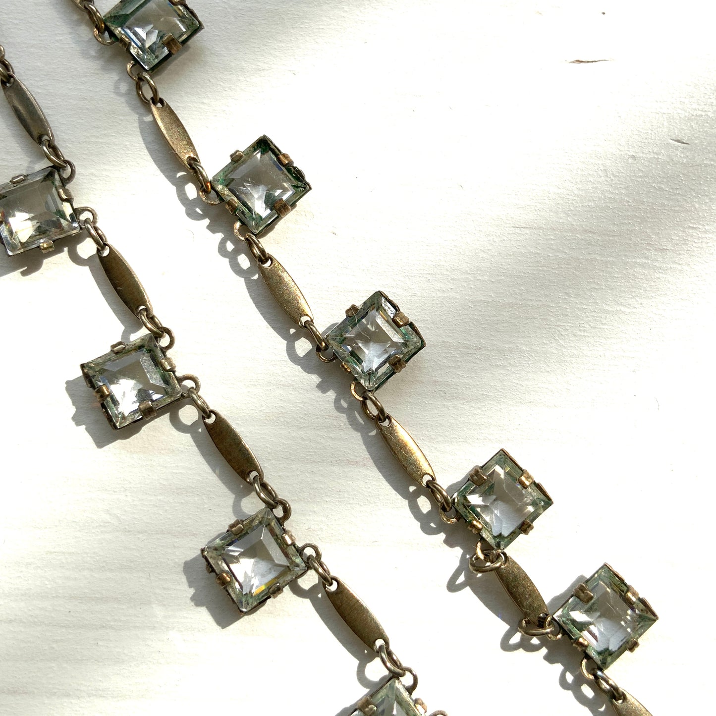 A classic Art Deco silver necklace set with square-cut clear glass stones. クラシックなスクエアカットのクリアグラスが並ぶ、アールデコのシルバーネックレス。