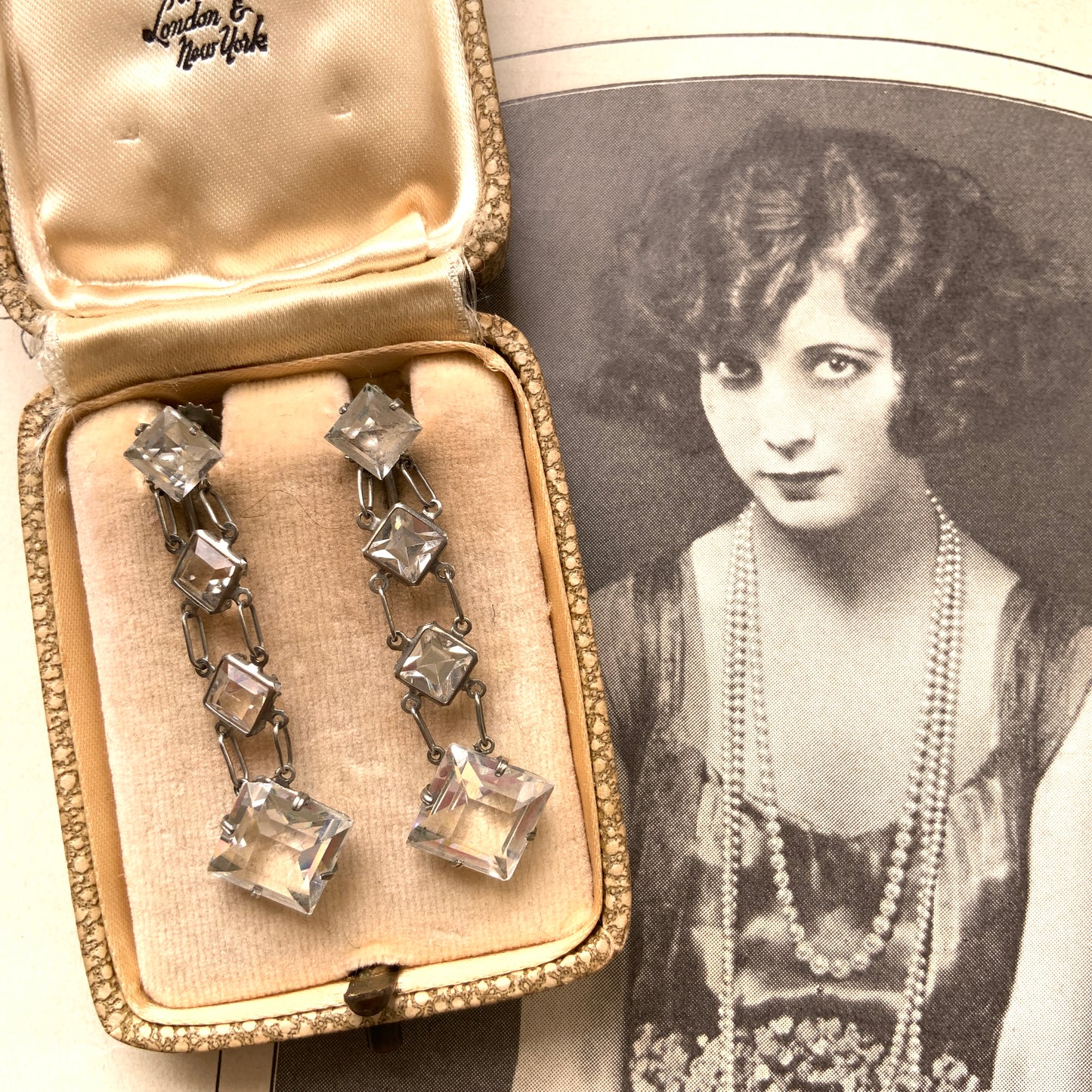 Screw-back earrings featuring clear diamond-shaped glass drops.クリアのダイヤ型グラスが揺れる、スクリューイヤリング。
