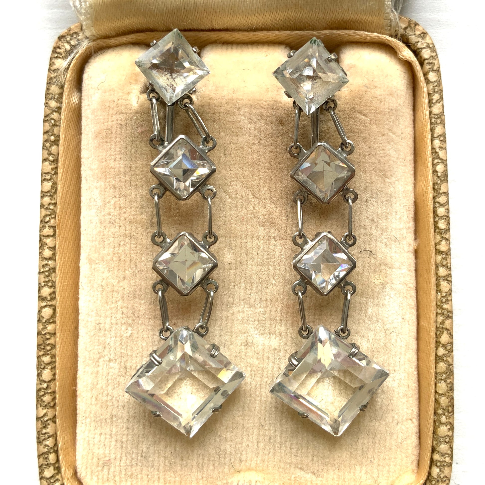 Screw-back earrings featuring clear diamond-shaped glass drops.クリアのダイヤ型グラスが揺れる、スクリューイヤリング。