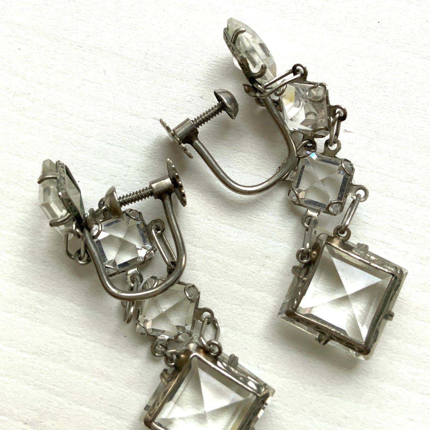 Screw-back earrings featuring clear diamond-shaped glass drops.クリアのダイヤ型グラスが揺れる、スクリューイヤリング。