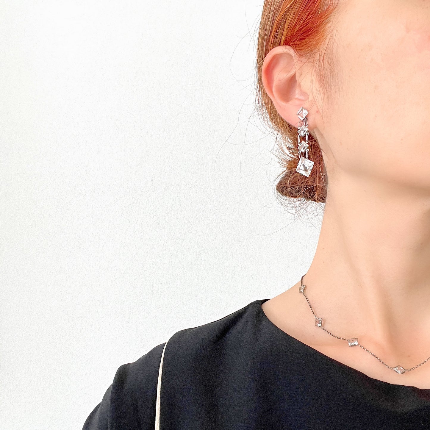 Screw-back earrings featuring clear diamond-shaped glass drops.クリアのダイヤ型グラスが揺れる、スクリューイヤリング。