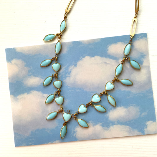 This necklace features a delicate chain of pale turquoise heart-shaped glass links, accented with marquise-shaped glass fringe. 淡いターコイズカラーのハートグラスチェーンに、マーキス 型のグラスのフリンジがついたネックレス。