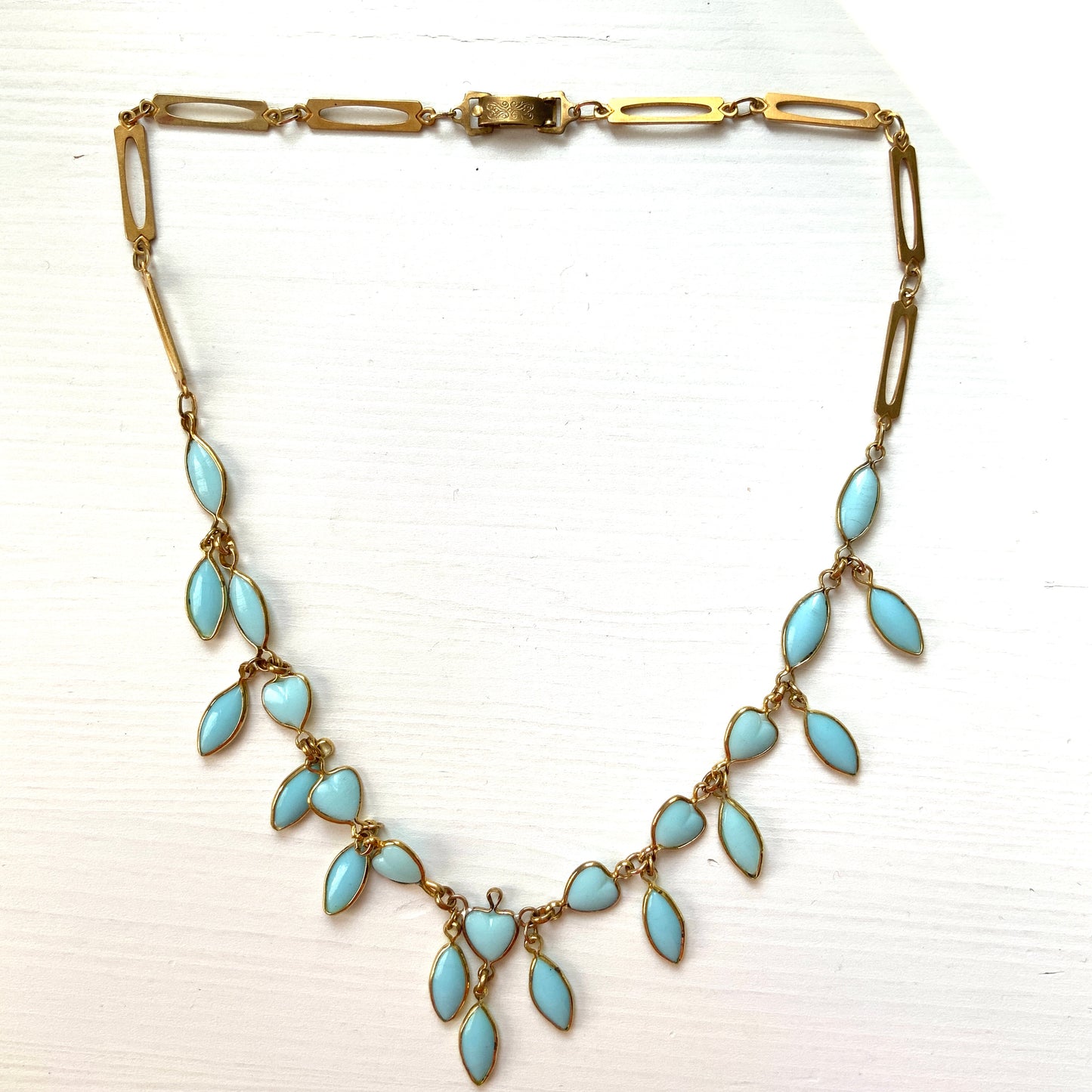 This necklace features a delicate chain of pale turquoise heart-shaped glass links, accented with marquise-shaped glass fringe. 淡いターコイズカラーのハートグラスチェーンに、マーキス 型のグラスのフリンジがついたネックレス。